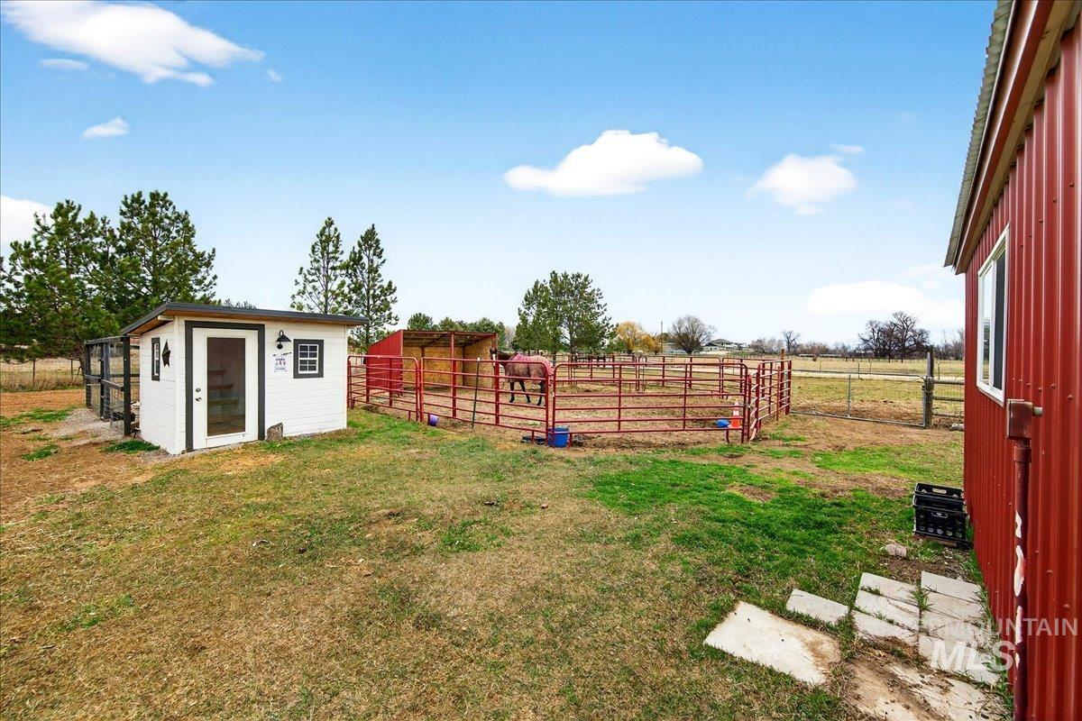 View of yard featuring an outbuilding, a view of countryside, and an exterior structure