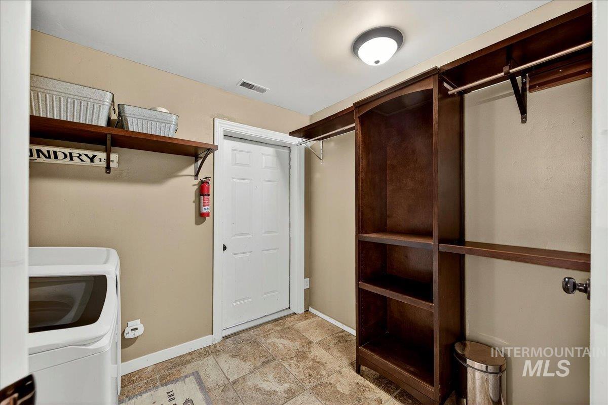 Laundry room featuring baseboards and washing machine and dryer