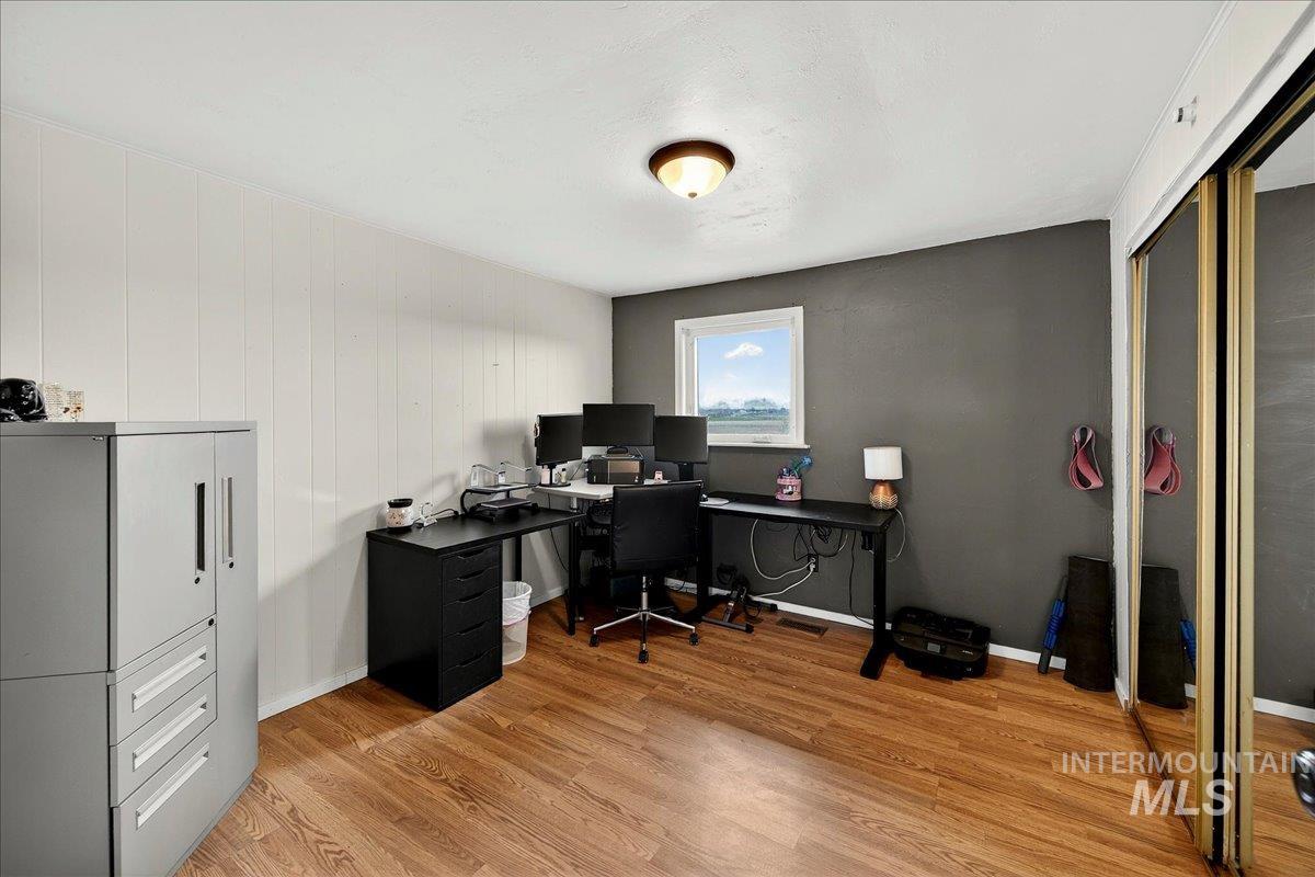 Office with light wood-type flooring and baseboards