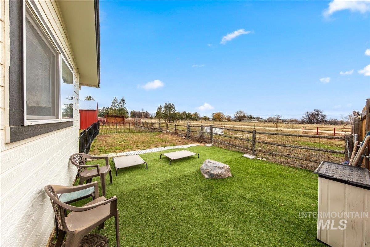 Fenced backyard featuring a view of countryside