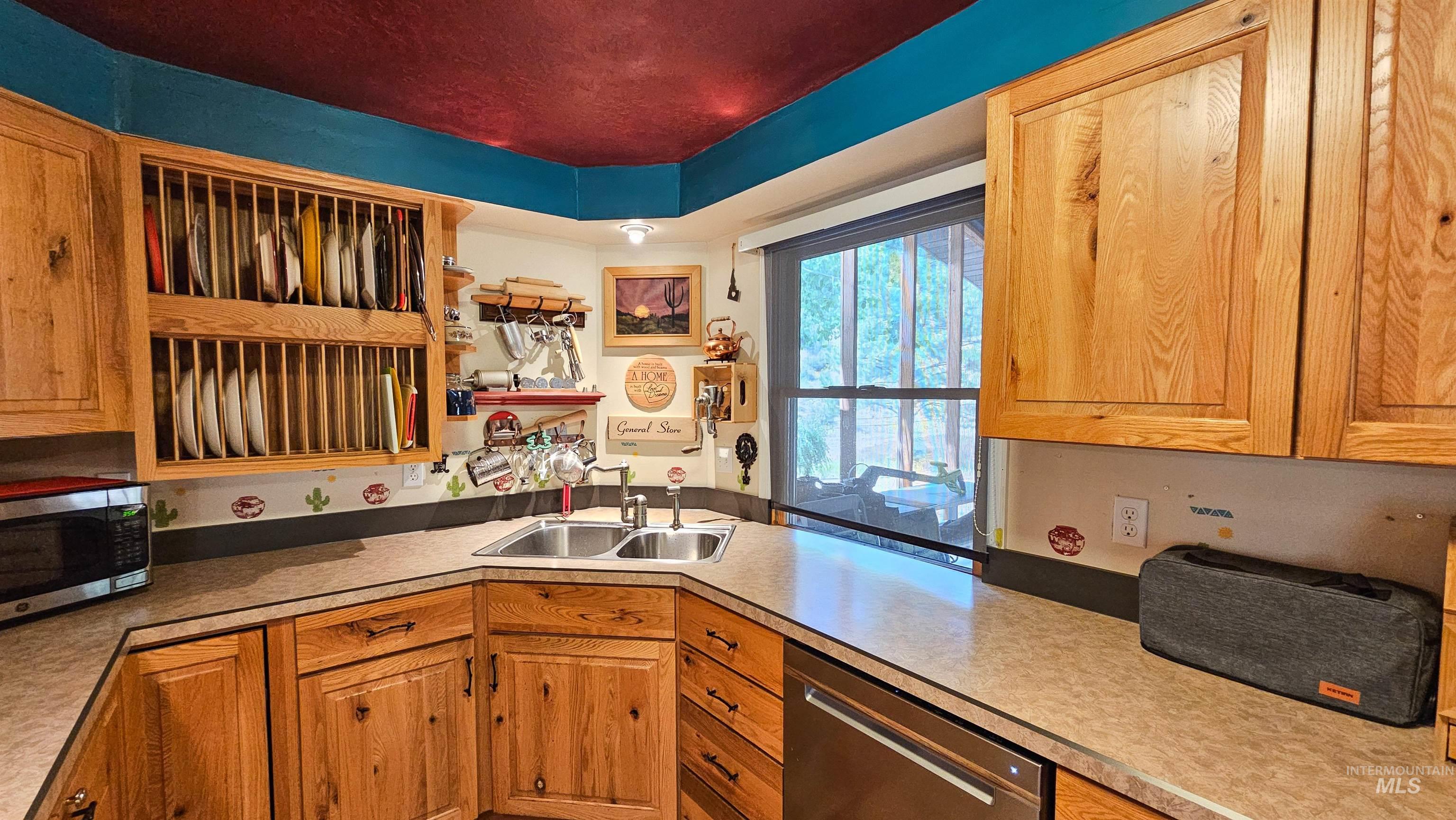 Kitchen featuring stainless steel appliances, light countertops, and brown cabinetry