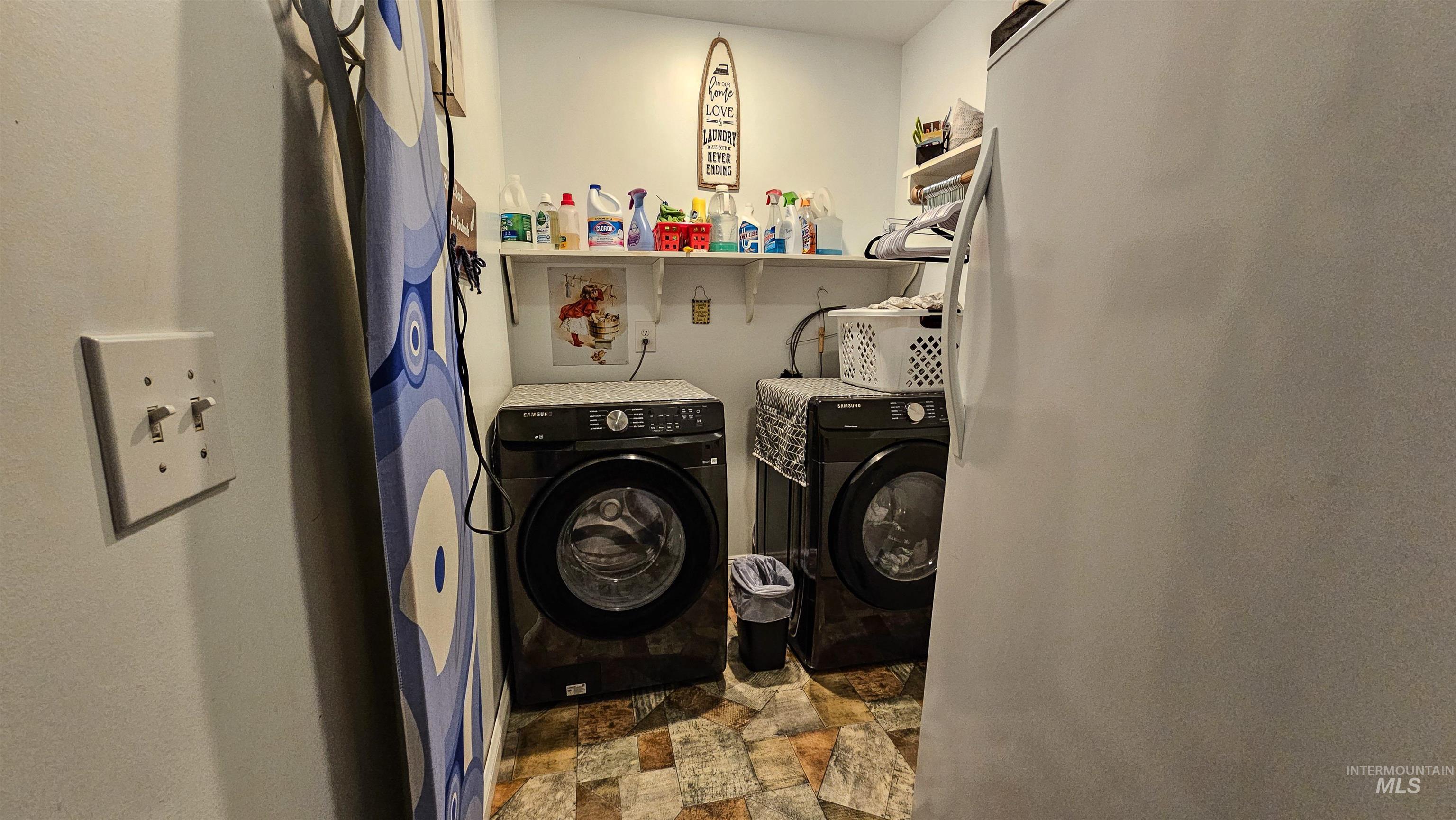 Laundry room featuring separate washer and dryer and stone finish flooring