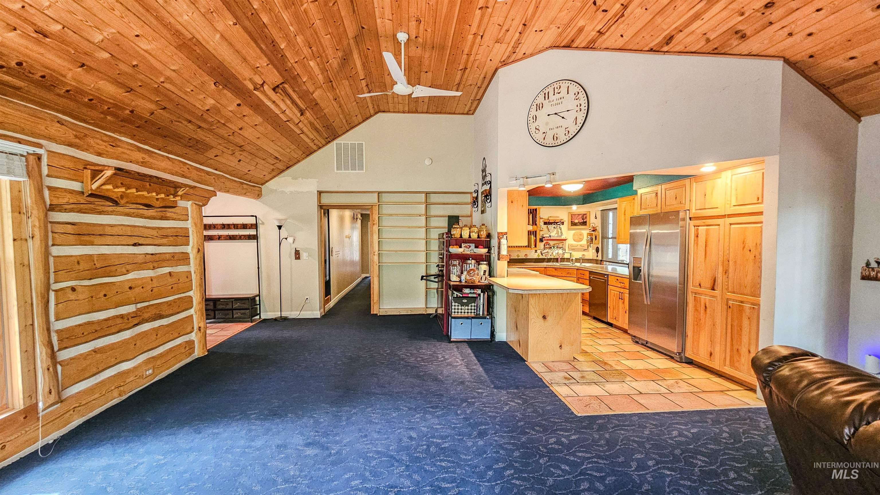 Kitchen with open floor plan, wooden ceiling, stainless steel appliances, high vaulted ceiling, and a peninsula
