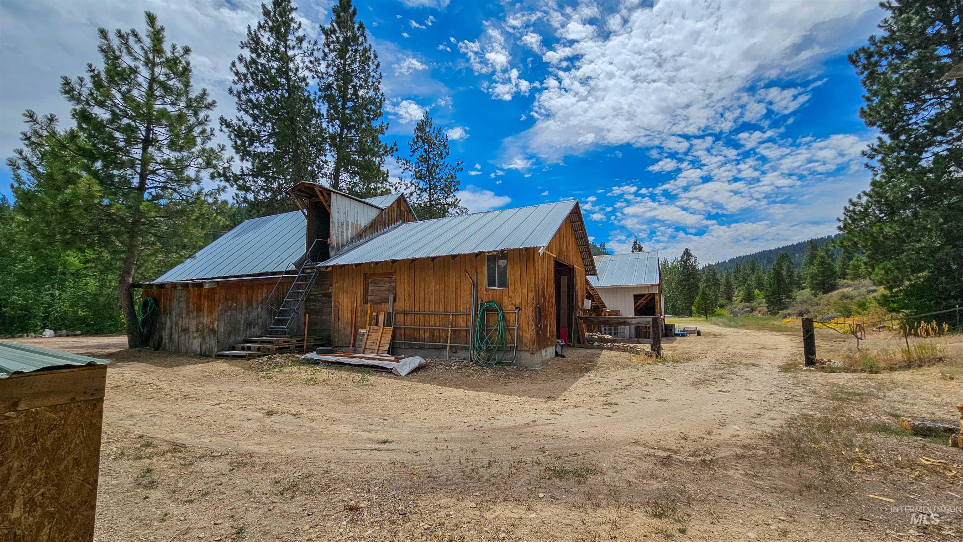 View of property exterior with a metal roof, an outdoor structure, board and batten siding, and an exterior structure