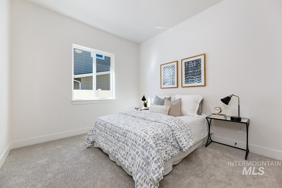 Bedroom featuring baseboards and light carpet