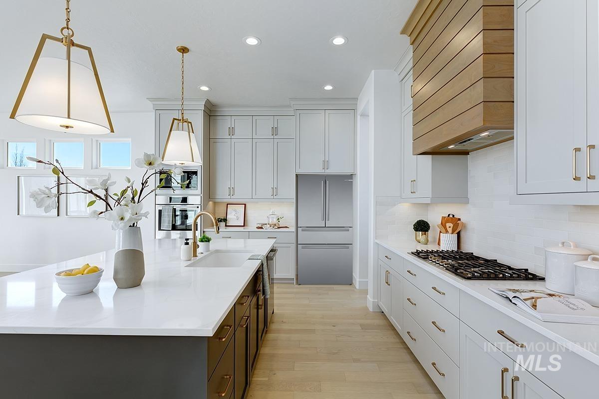 Kitchen with recessed lighting, light wood-style floors, stainless steel appliances, a kitchen island with sink, and backsplash