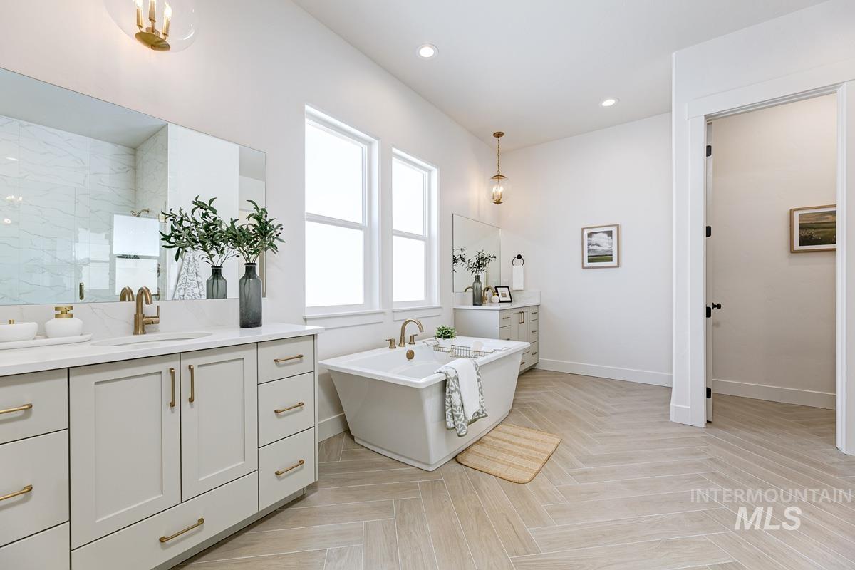 Full bath with a chandelier, vanity, a freestanding bath, recessed lighting, and walk in shower
