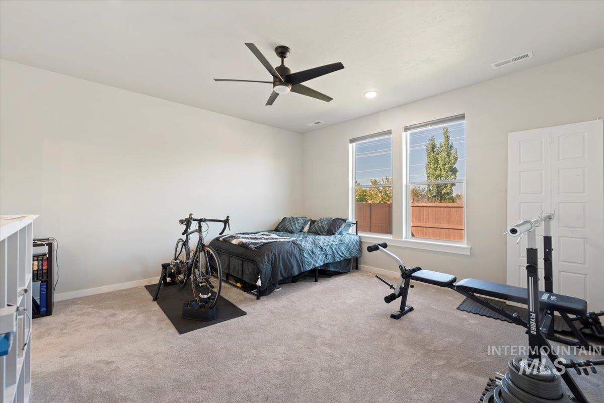 Bedroom with light carpet, ceiling fan, and recessed lighting