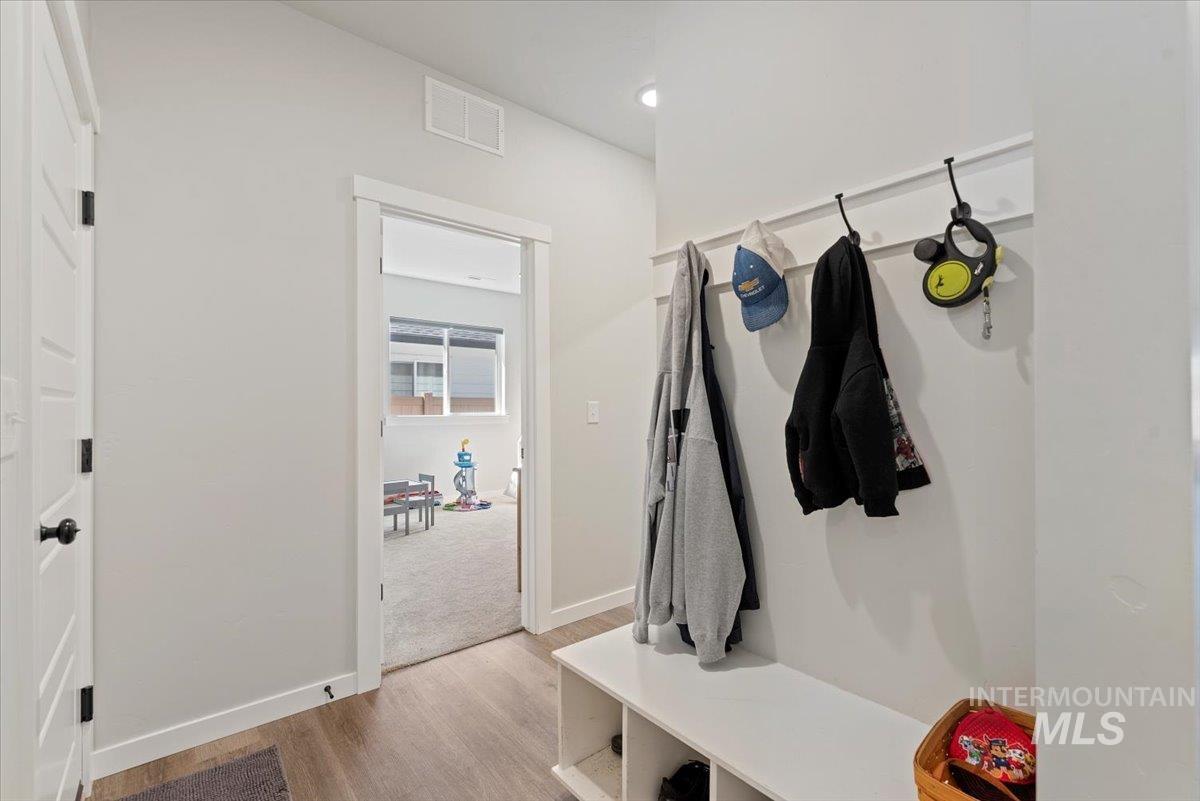 Mudroom with light wood-type flooring and baseboards