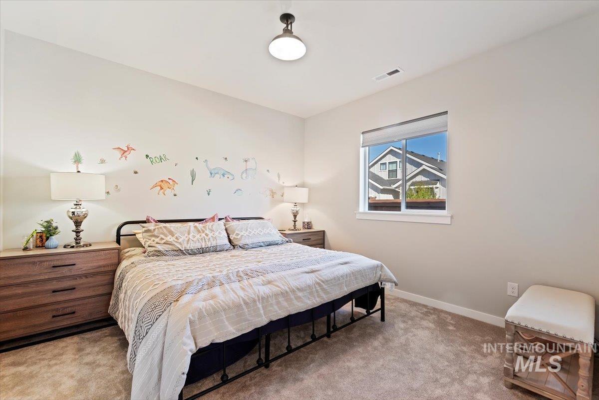 Bedroom featuring light colored carpet and baseboards