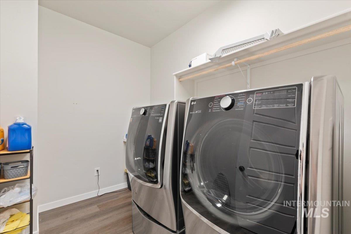 Laundry room featuring washer and clothes dryer and wood finished floors