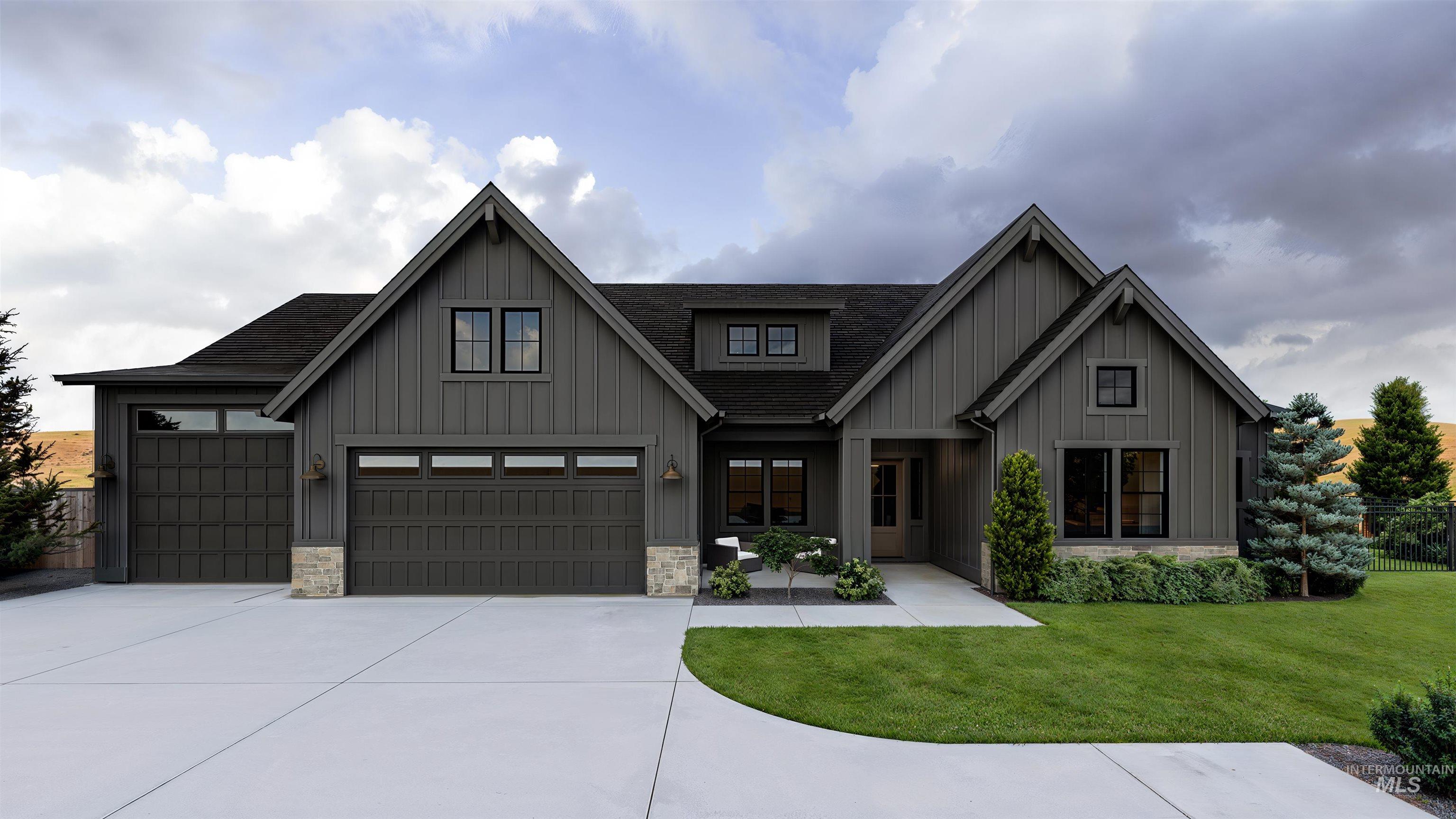 Modern farmhouse with board and batten siding, concrete driveway, a front yard, and roof with shingles
