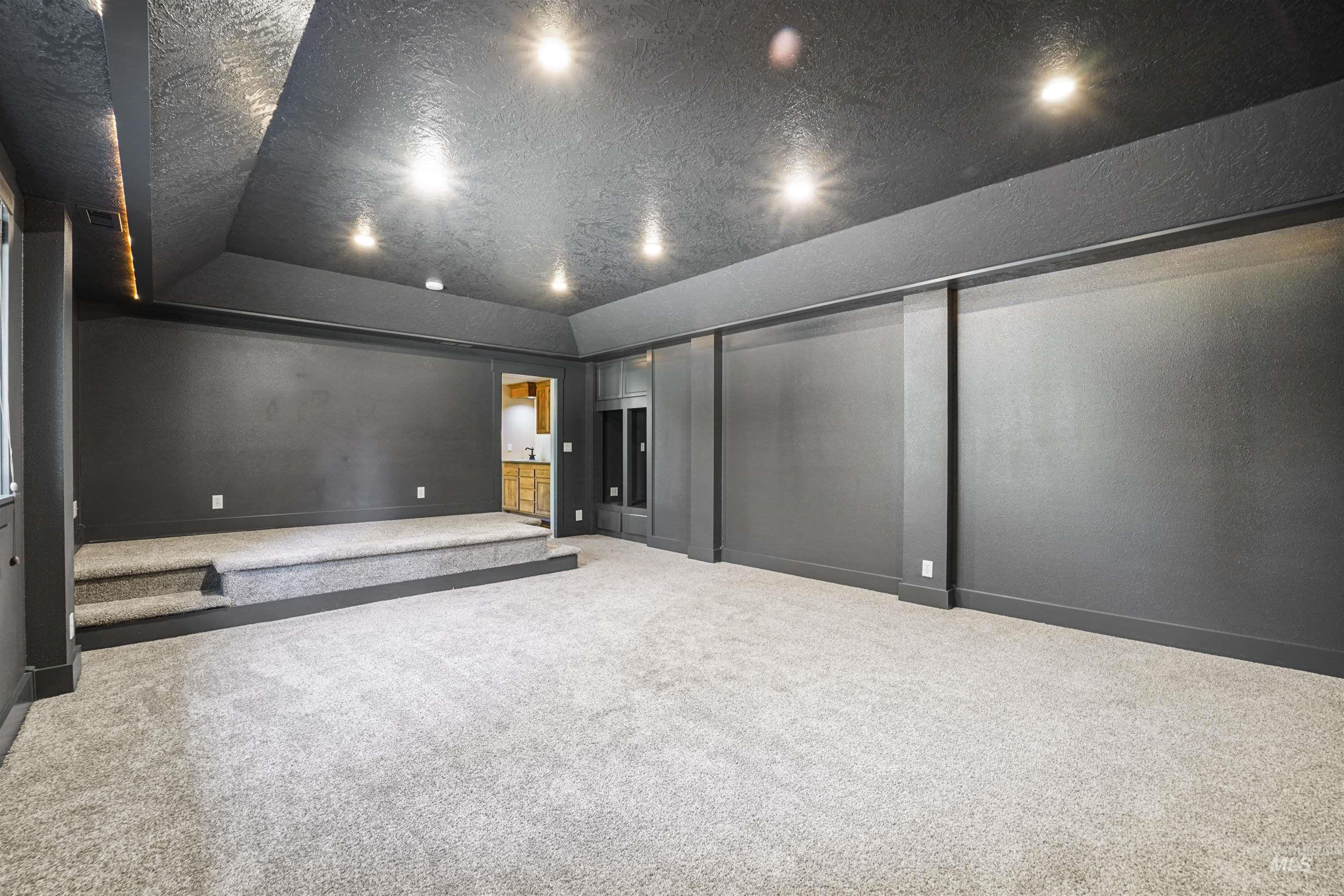 Home theater room featuring carpet flooring, recessed lighting, and a textured ceiling