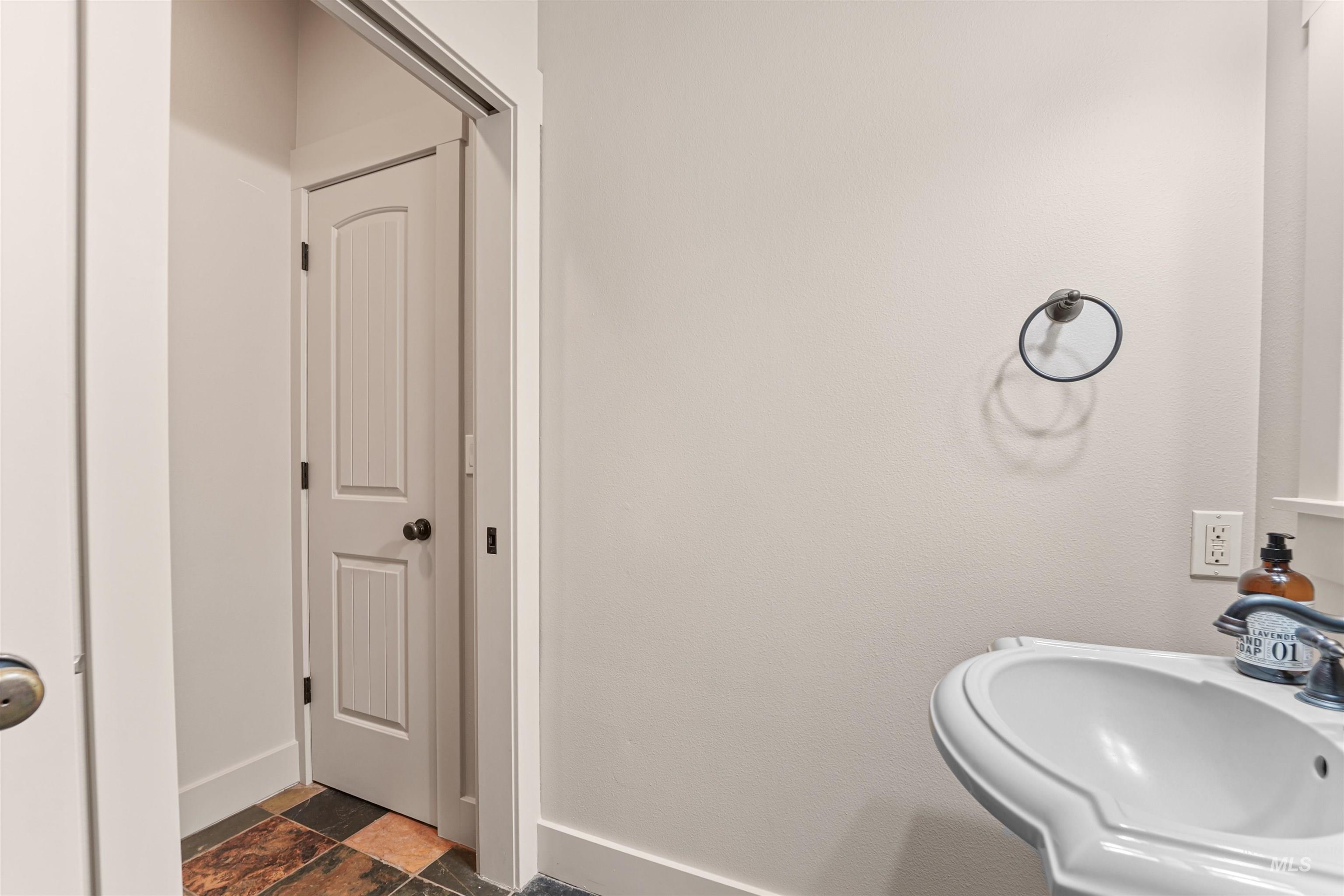 Bathroom with a sink and stone finish flooring