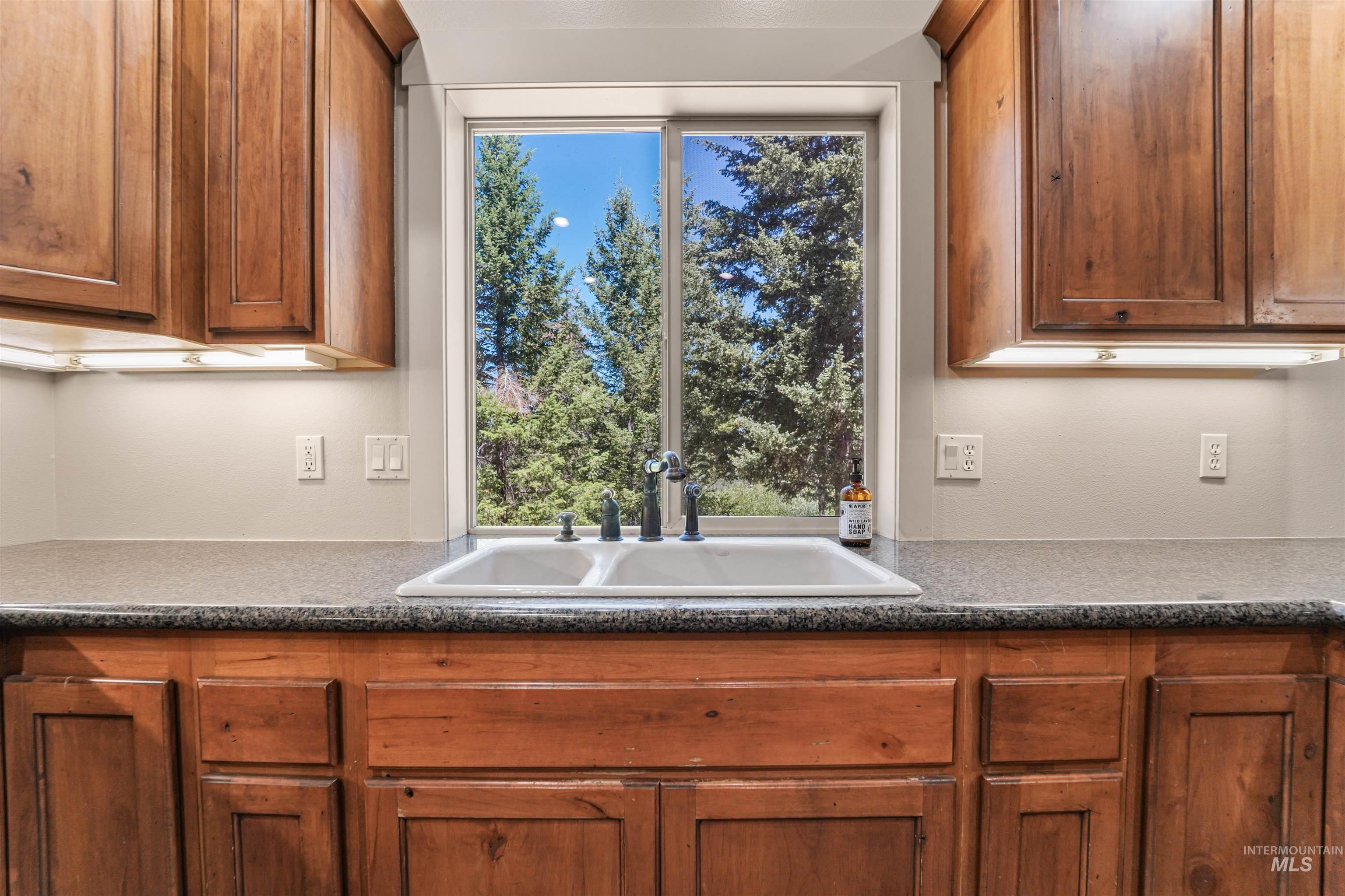 Kitchen with brown cabinetry and dark countertops