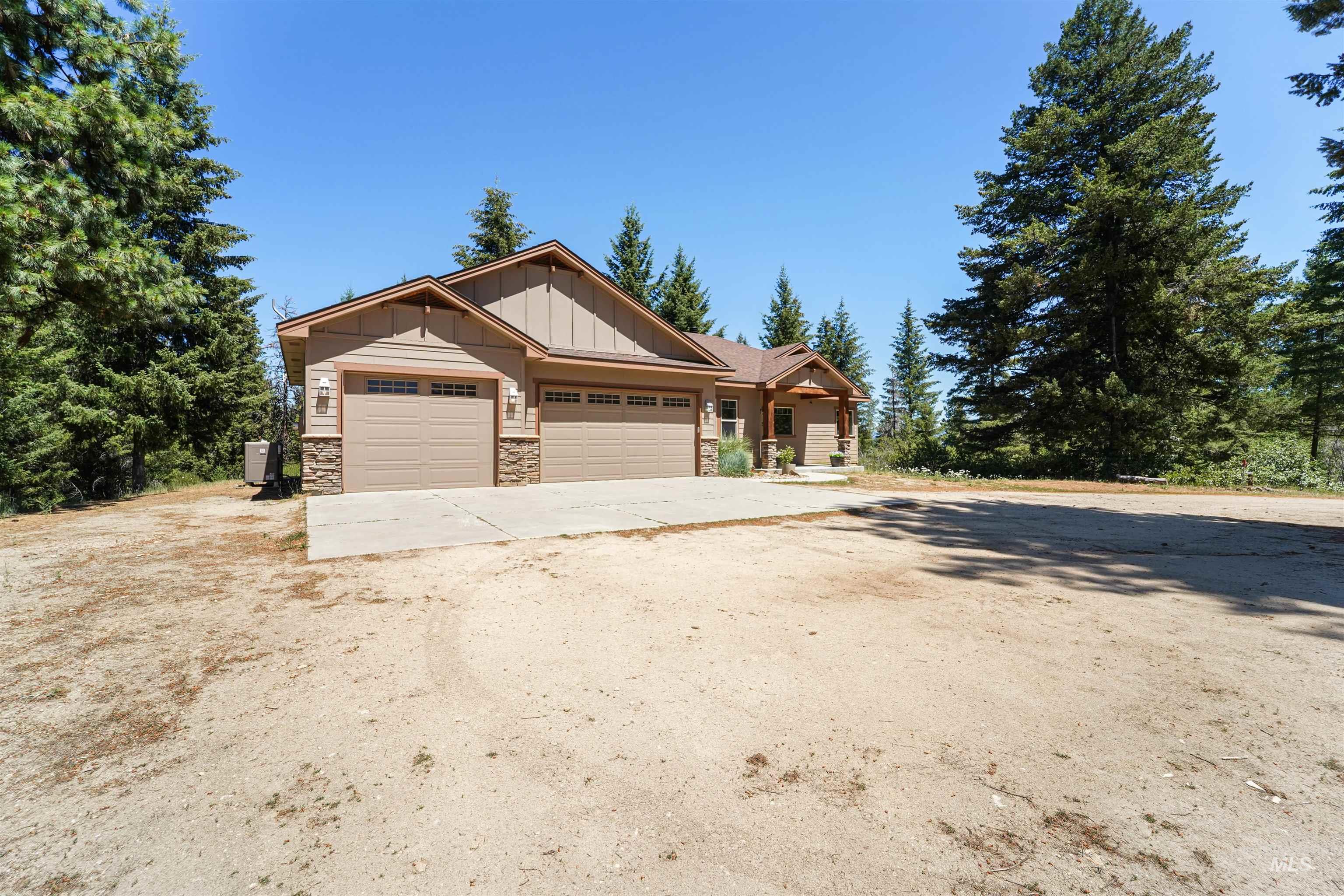 Craftsman-style home featuring concrete driveway, an attached garage, board and batten siding, and stone siding
