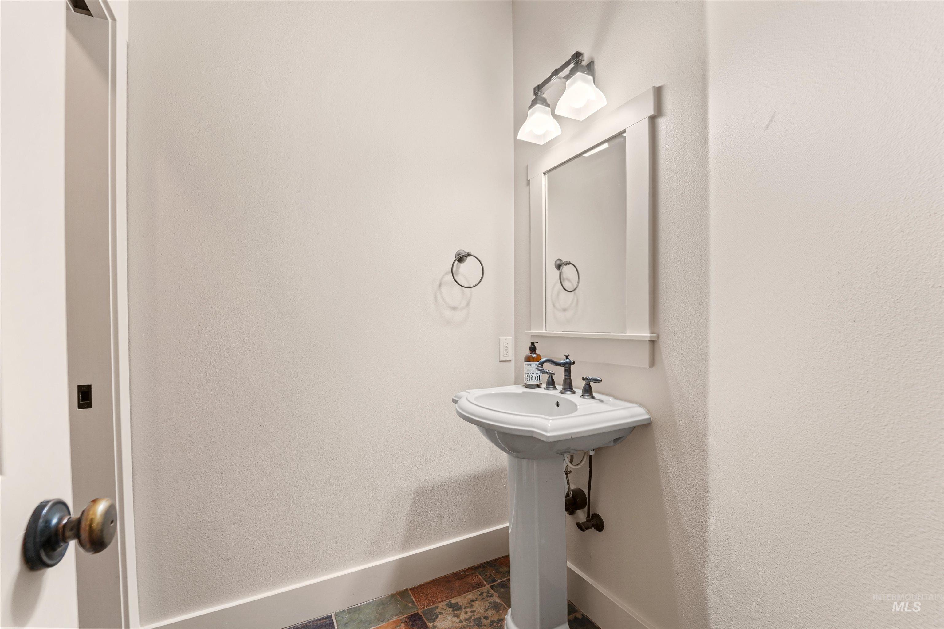 Bathroom featuring baseboards and stone finish flooring