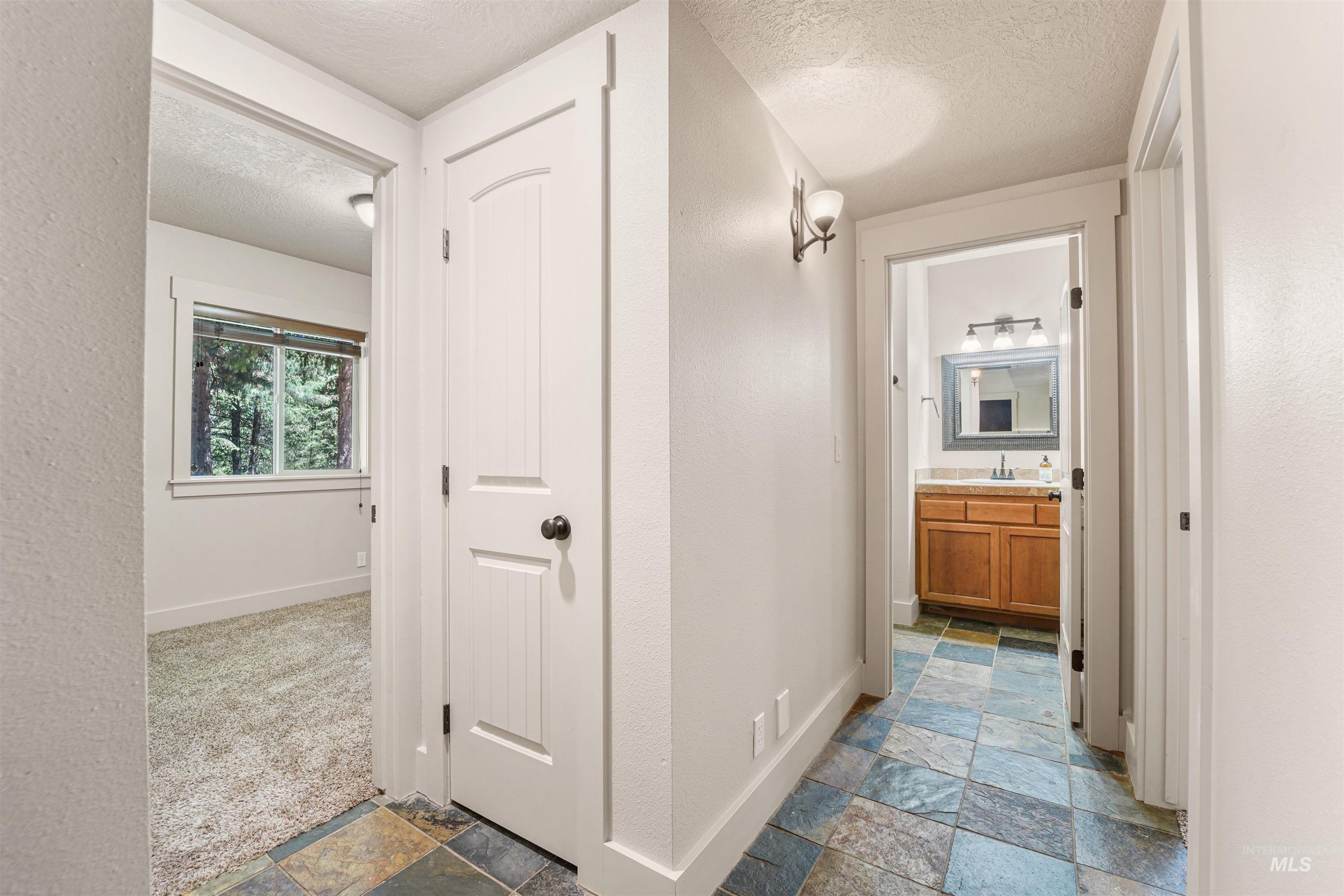Corridor featuring stone tile flooring and a textured ceiling