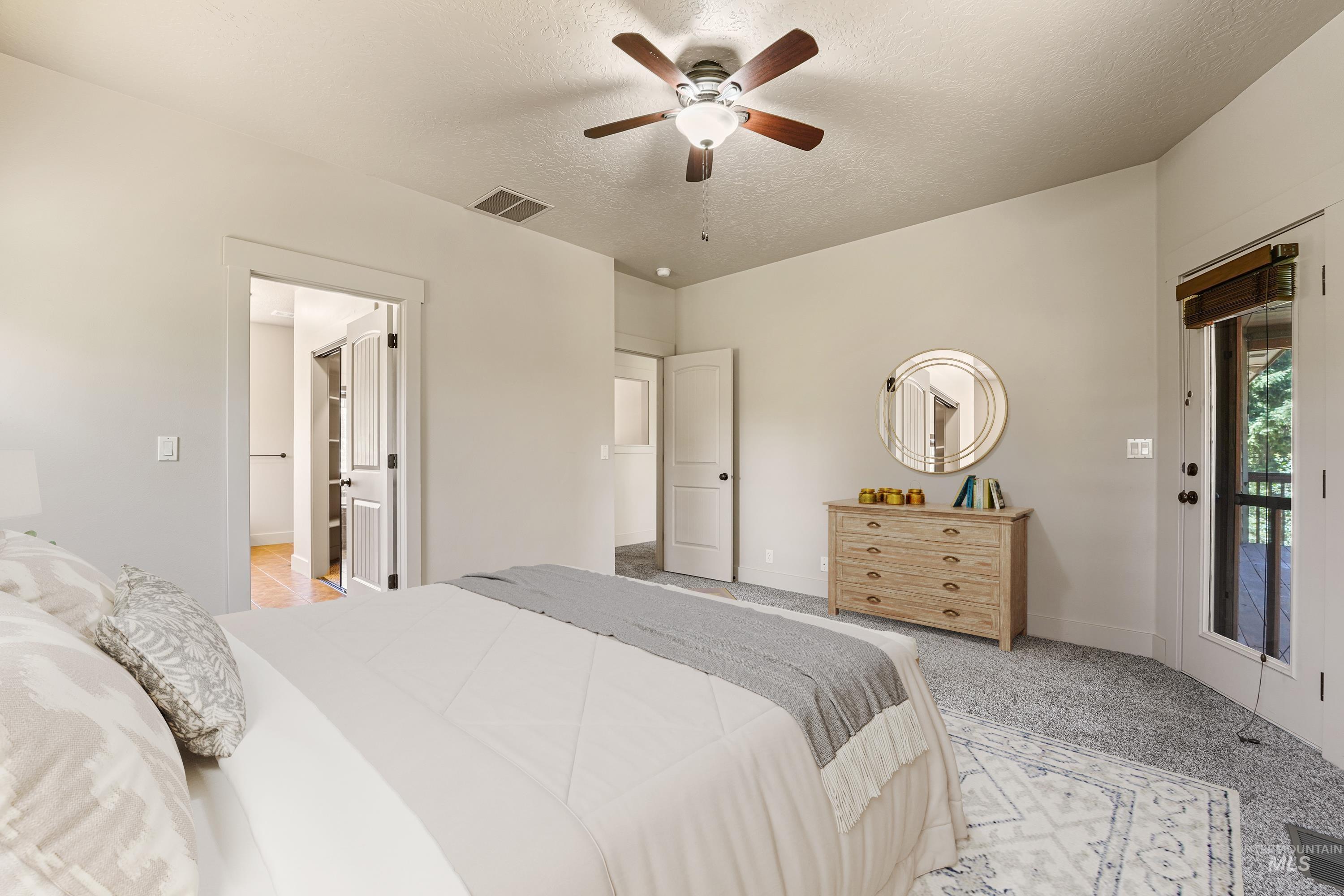 Bedroom featuring a textured ceiling, light carpet, a ceiling fan, and access to outside