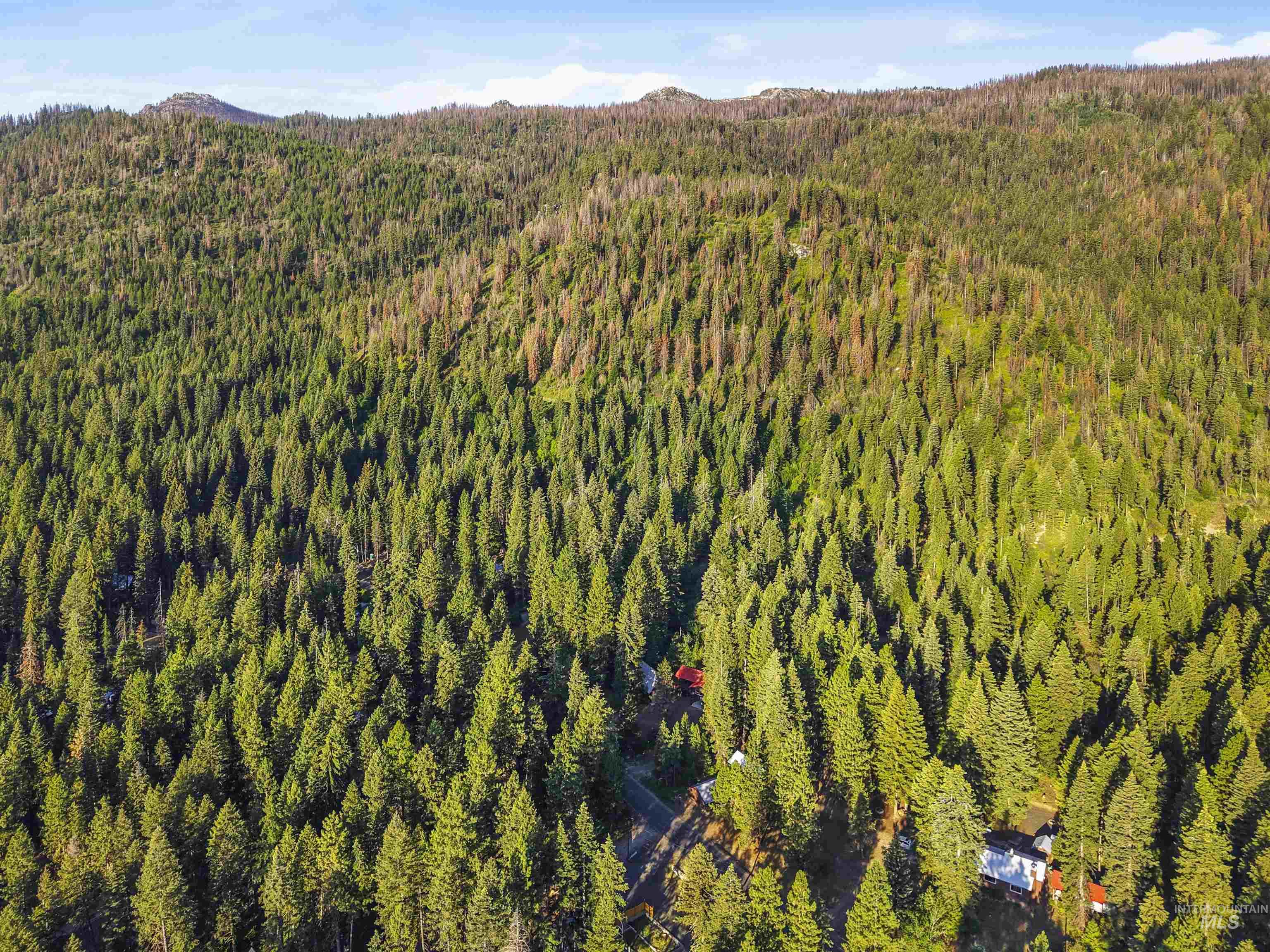 Aerial view of property and surrounding area featuring a mountainous background