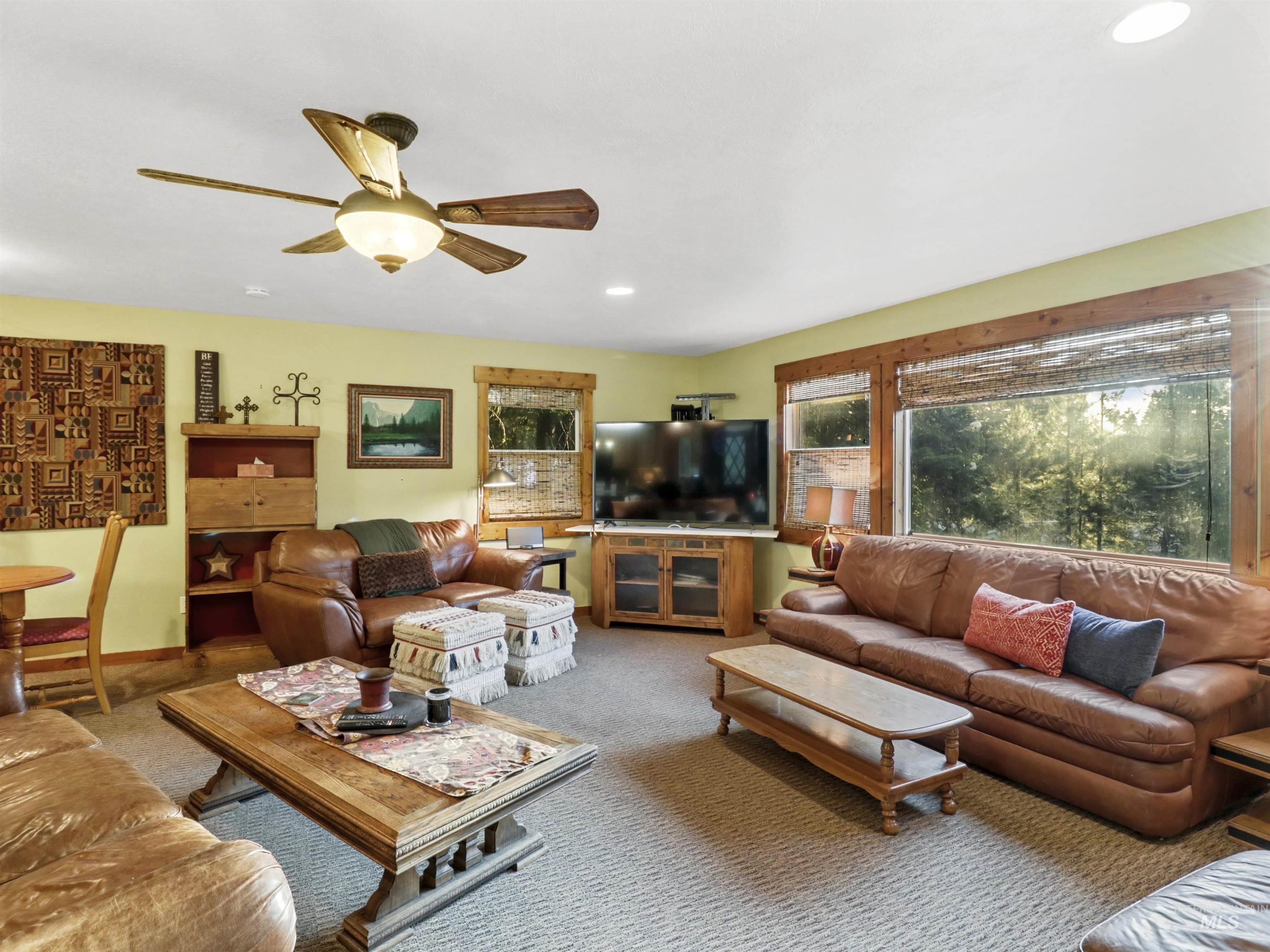 Carpeted living room with ceiling fan and recessed lighting
