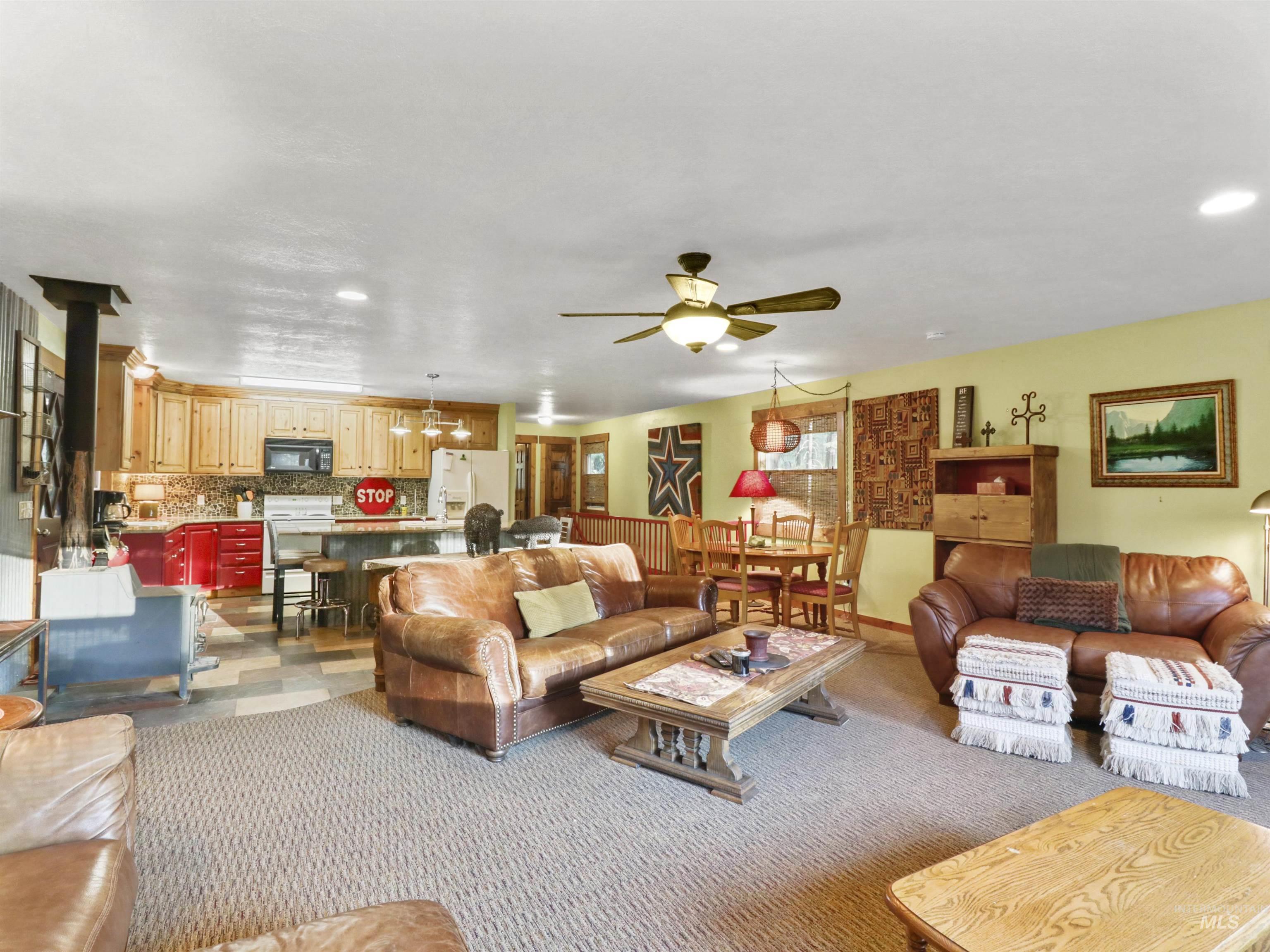 Living room featuring a ceiling fan, recessed lighting, and carpet flooring