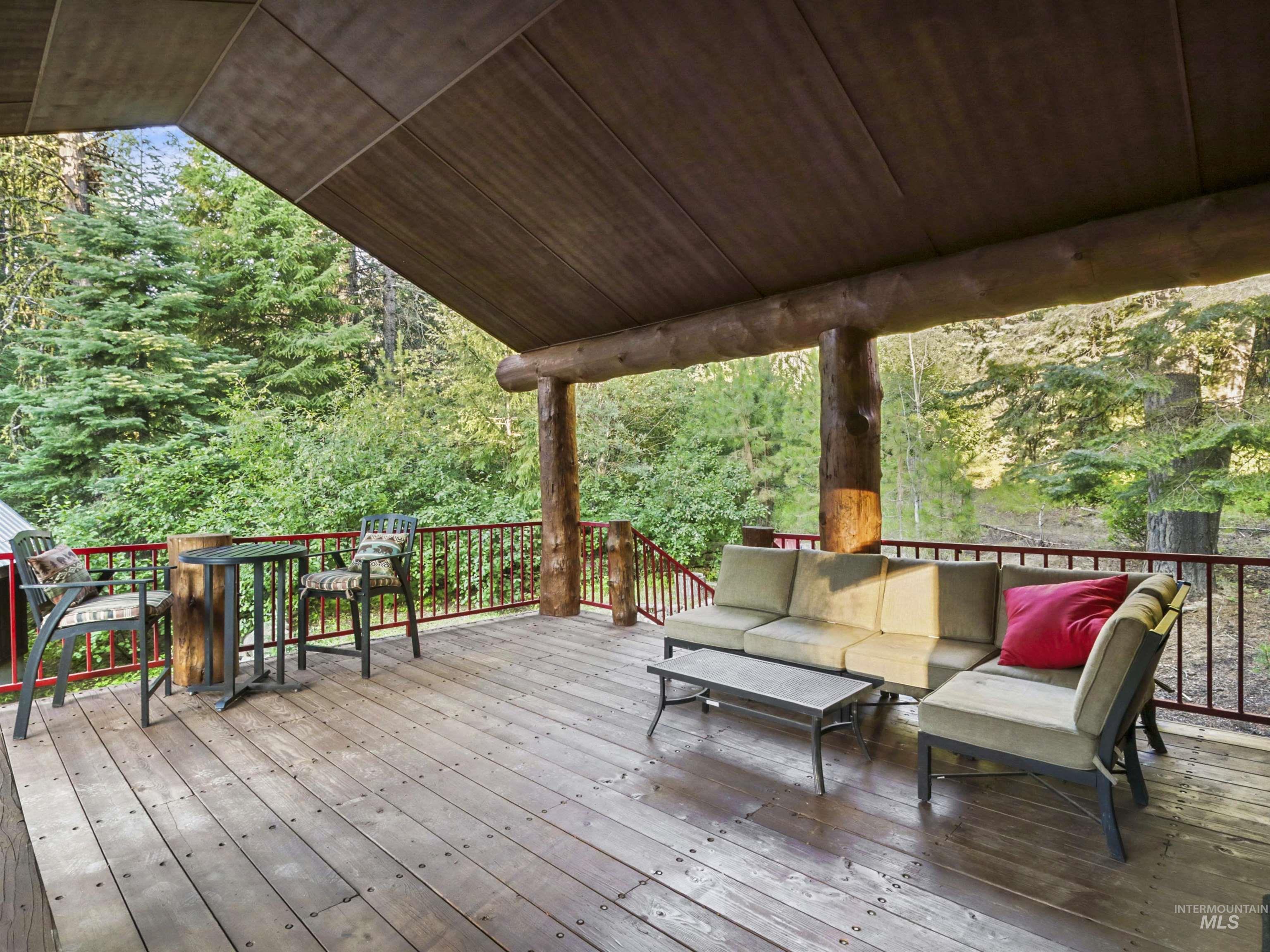 Wooden terrace featuring an outdoor hangout area and a wooded view