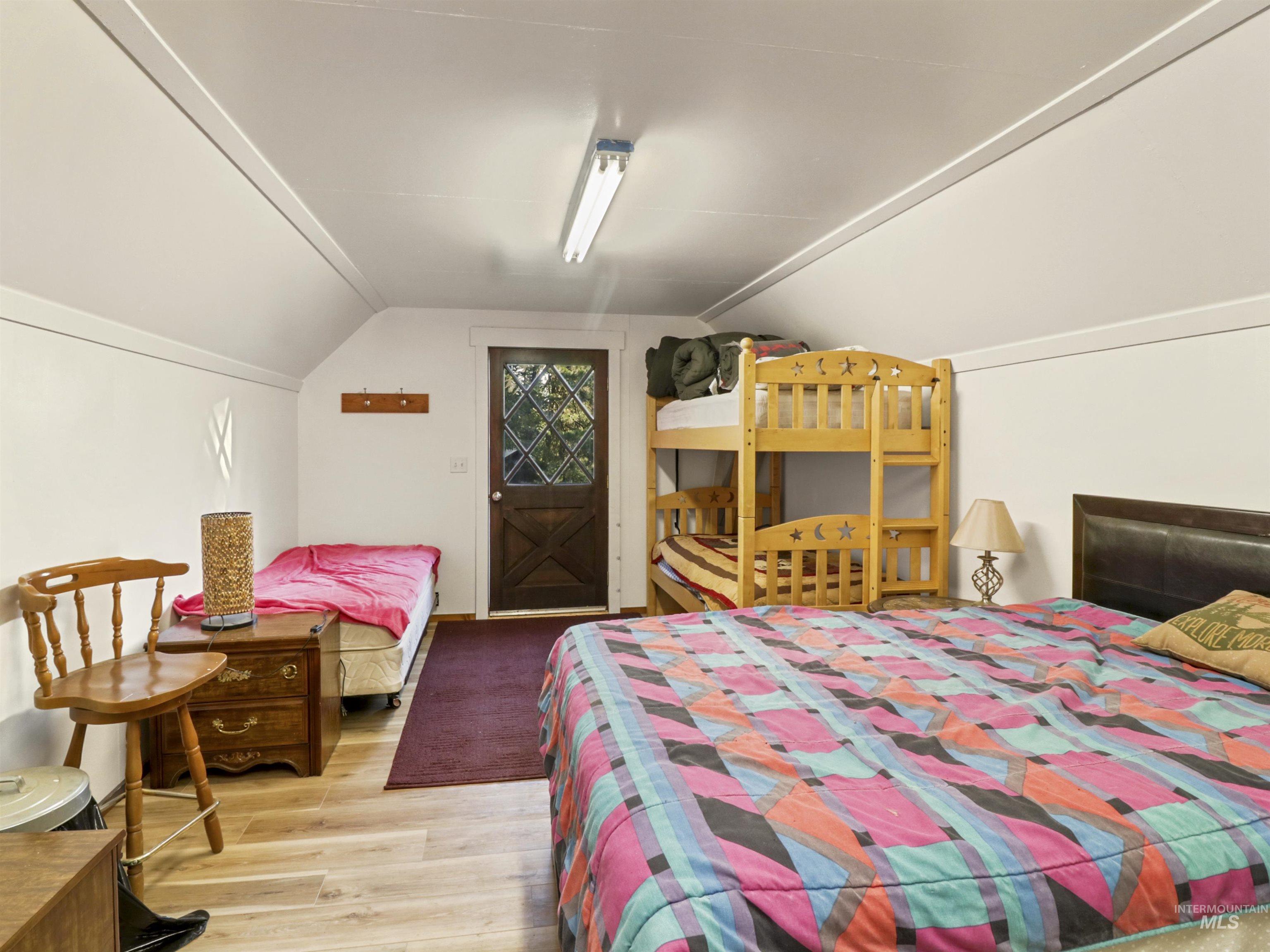 Bedroom with vaulted ceiling and wood finished floors