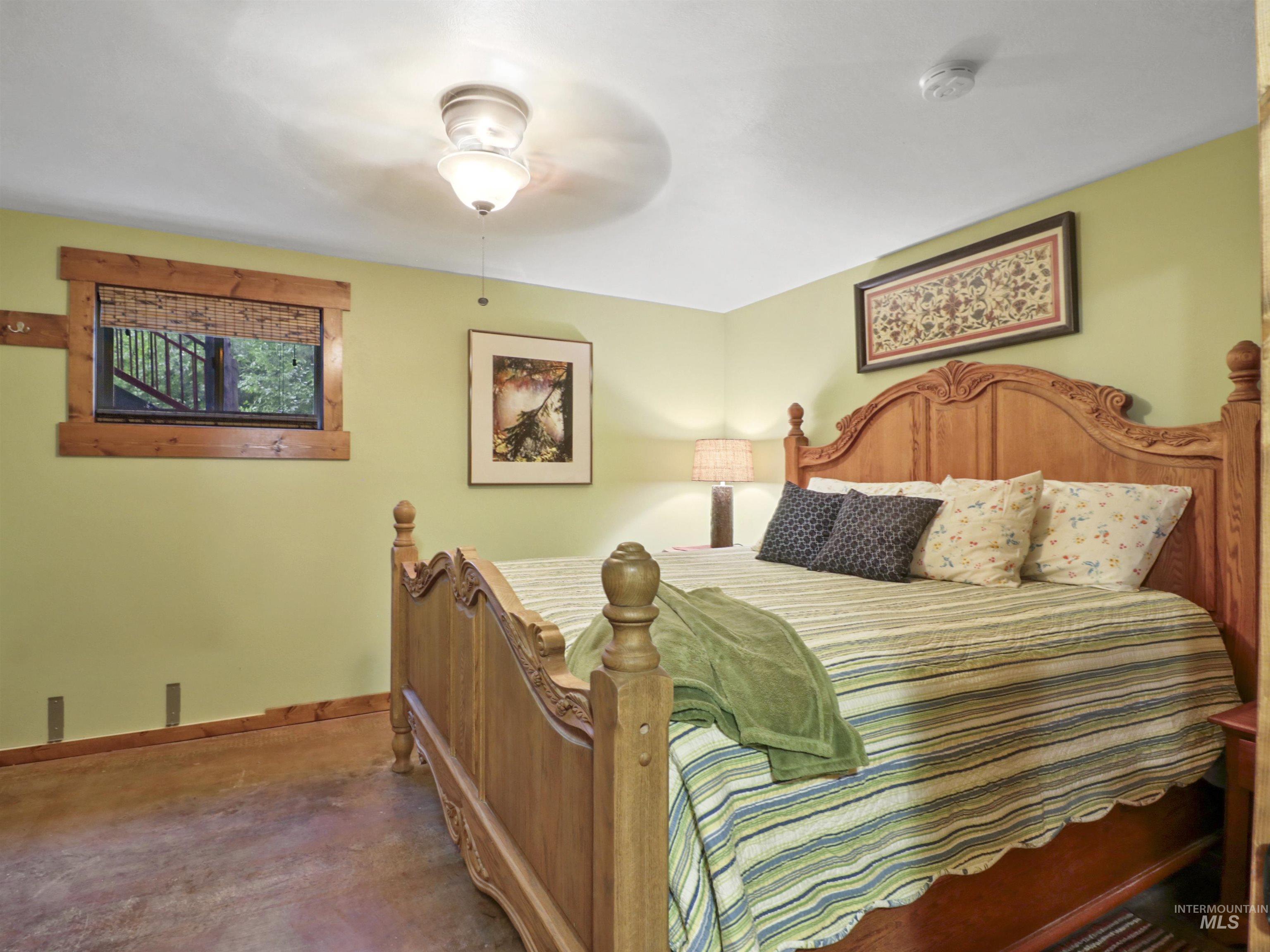 Bedroom featuring concrete floors and a ceiling fan