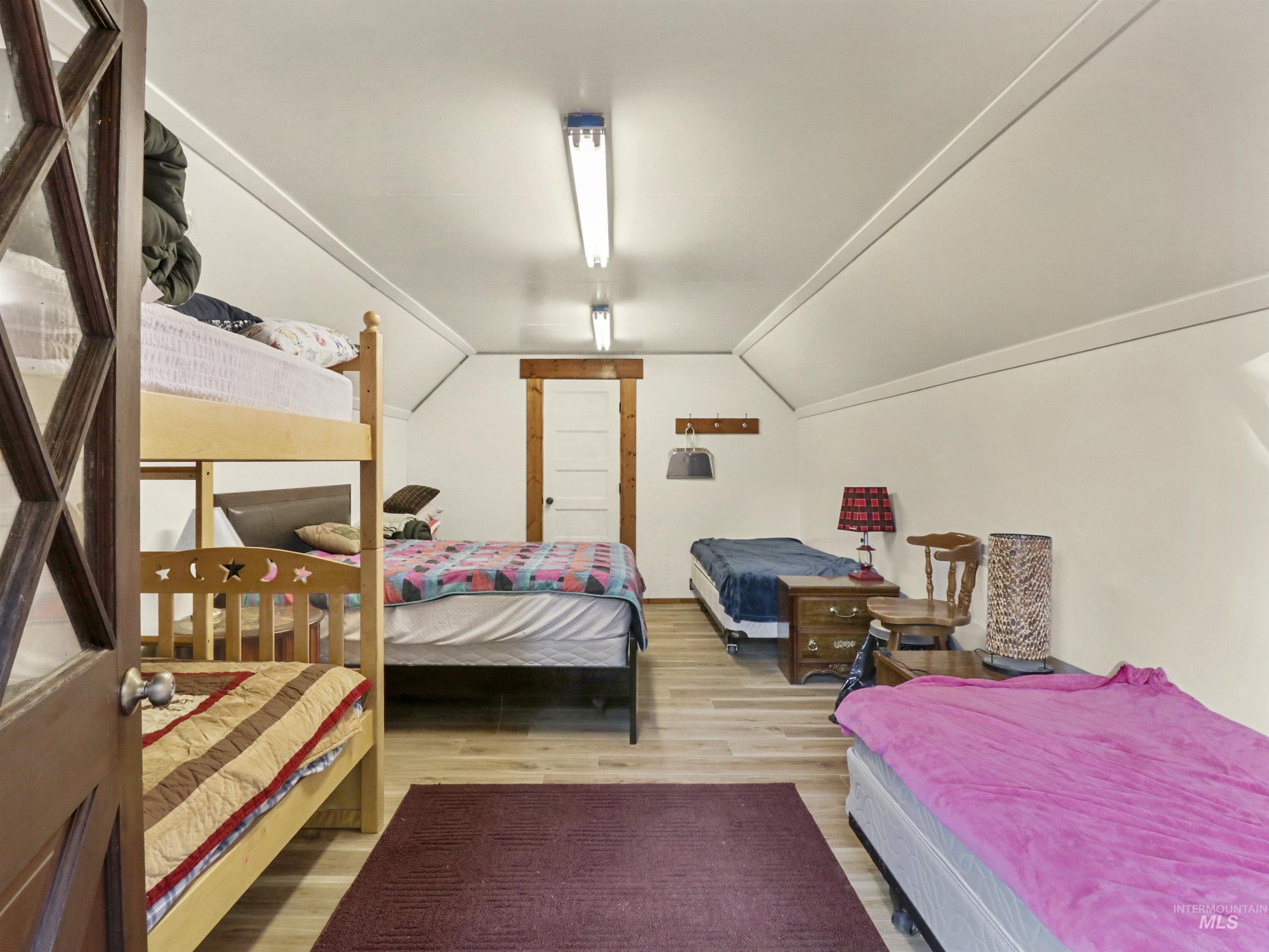 Bedroom featuring lofted ceiling and wood finished floors