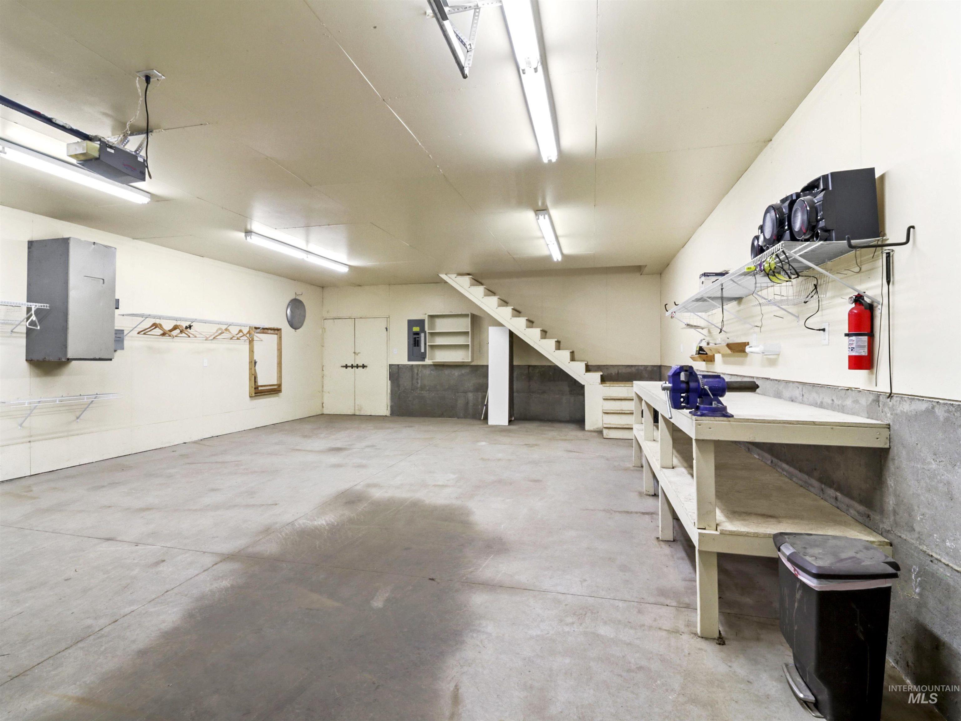 Garage featuring a workshop area, electric panel, and a garage door opener