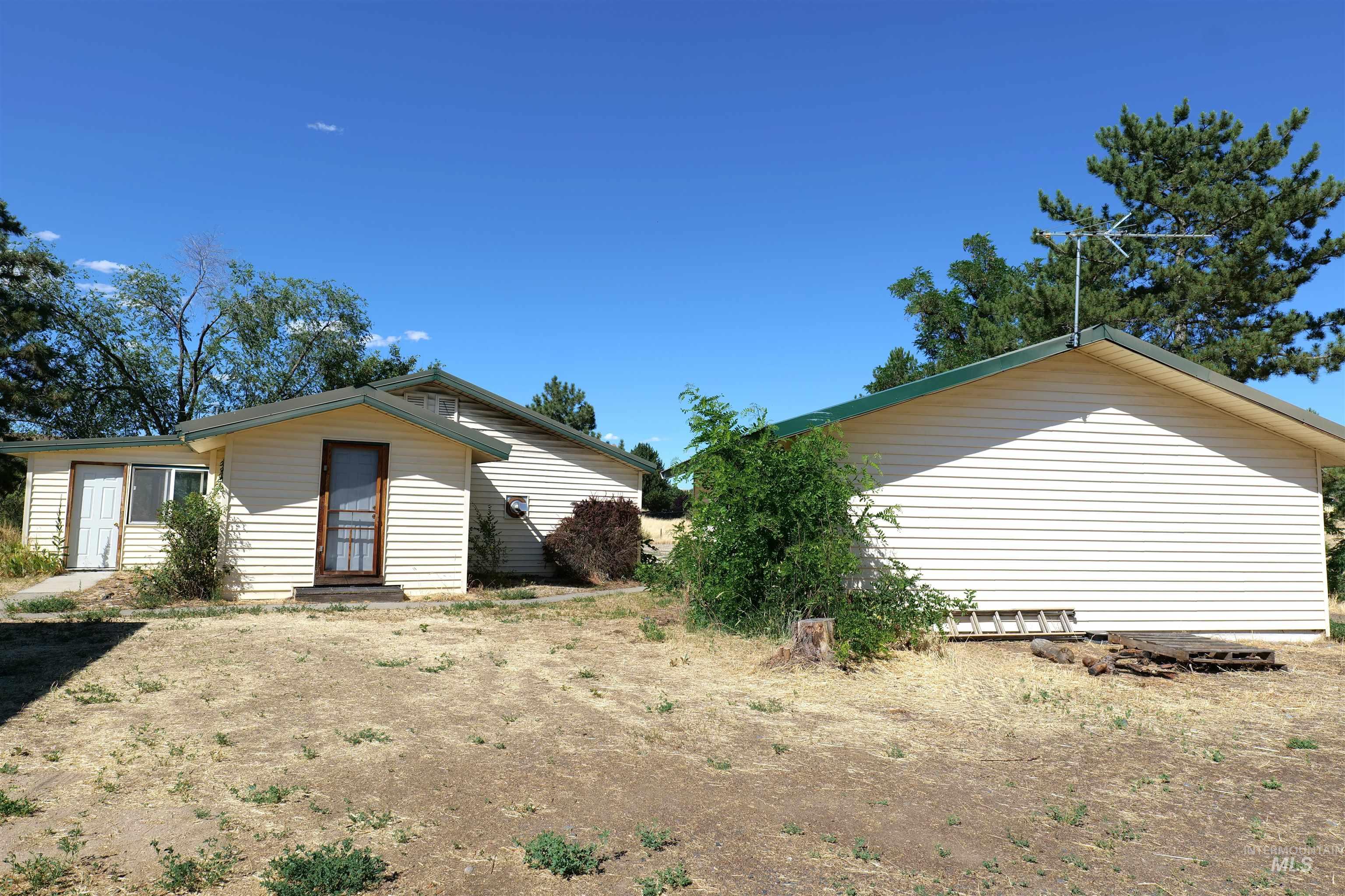 Property featuring light-colored horizontal siding and a green-trimmed roofline