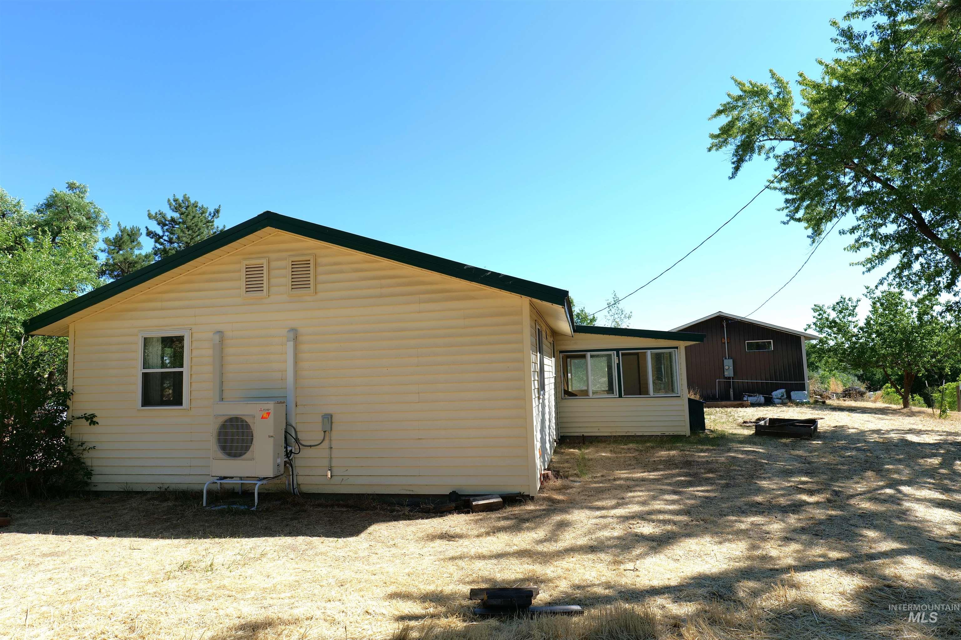 Light yellow horizontal vinyl siding exterior with a dark green roofline