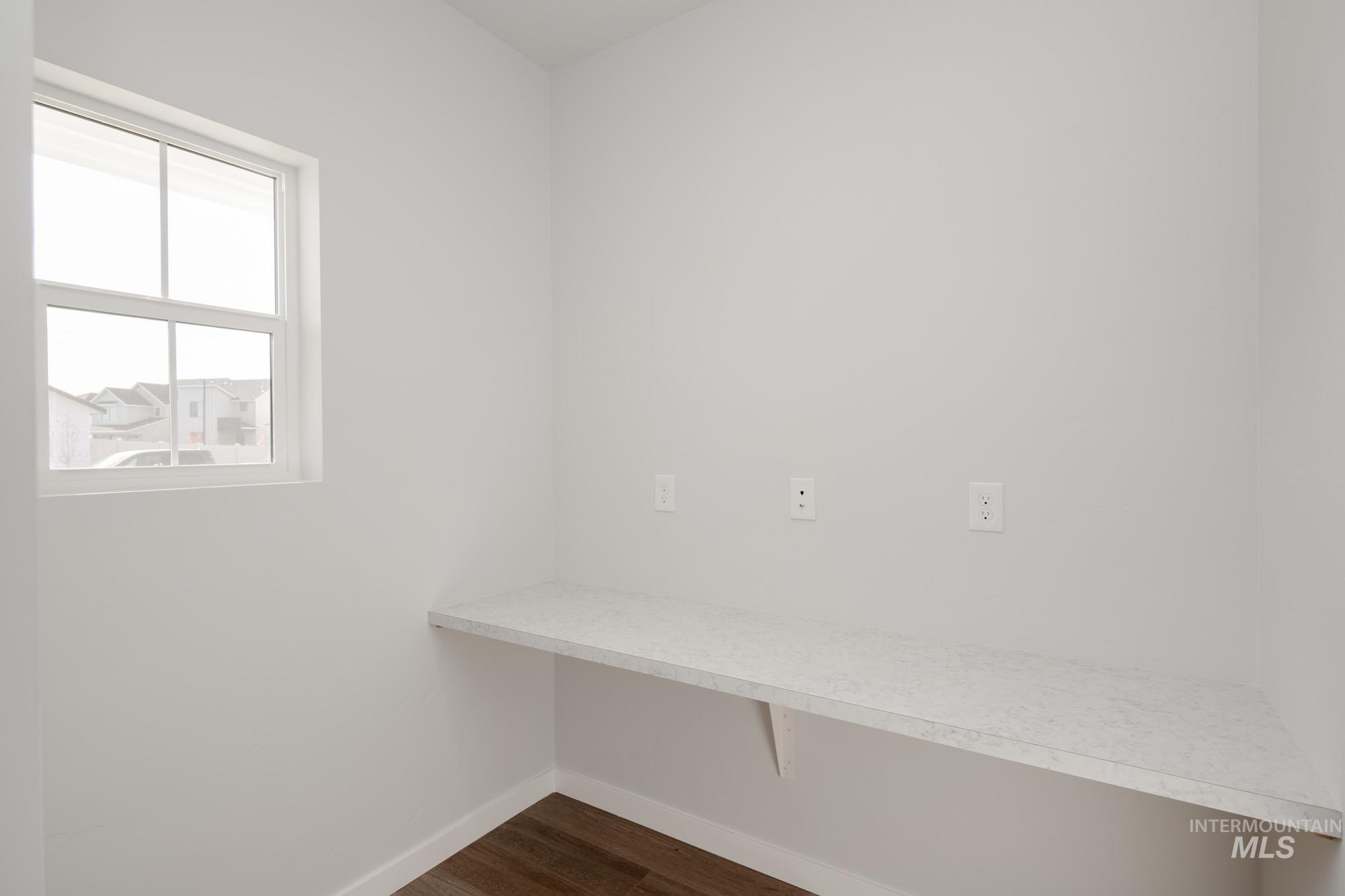 Mudroom featuring dark wood-style floors and baseboards
