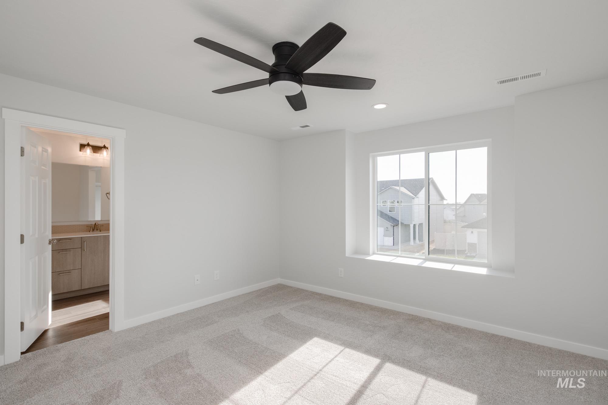 Unfurnished bedroom with light colored carpet, a ceiling fan, connected bathroom, and recessed lighting
