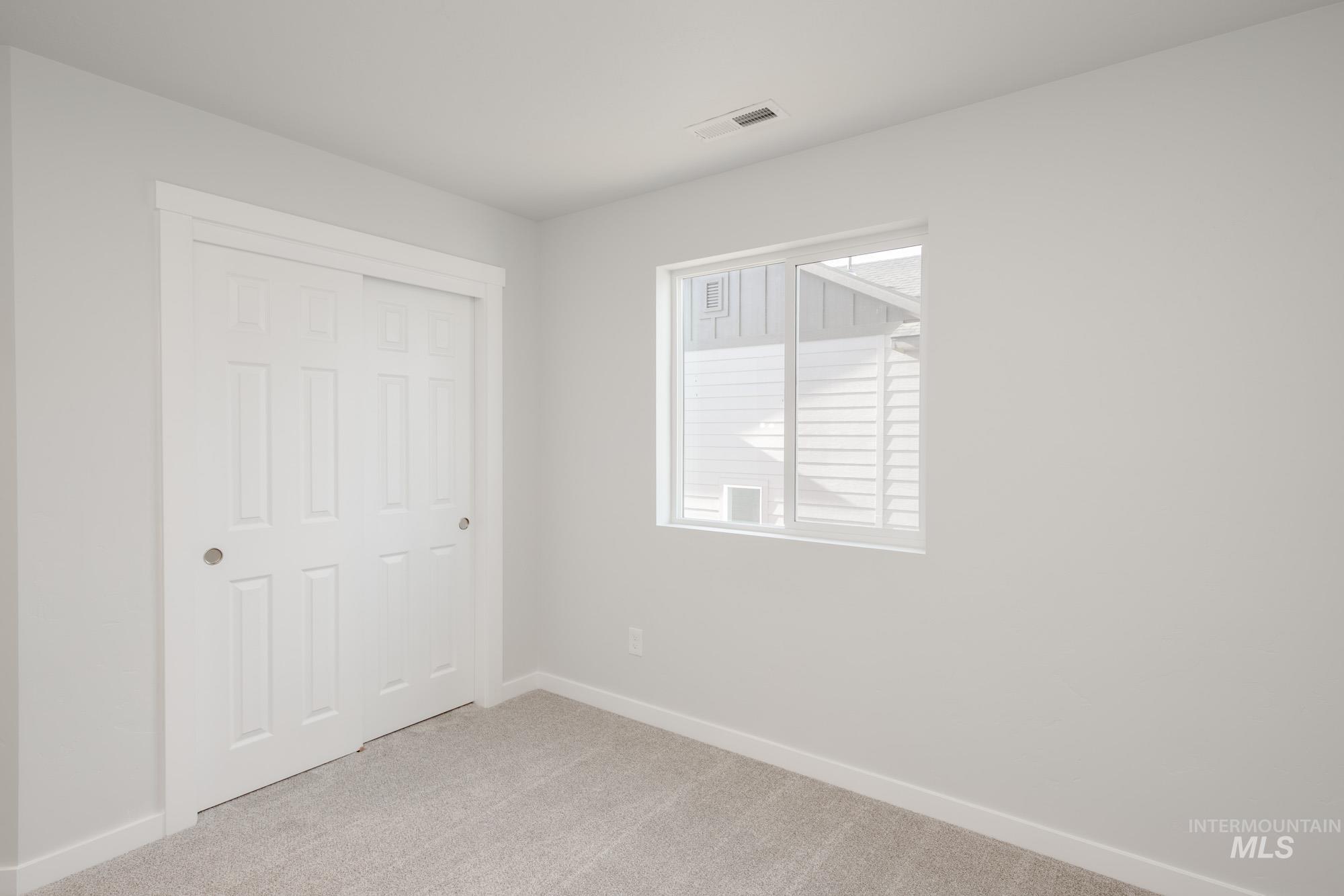 Unfurnished bedroom featuring light carpet and a closet