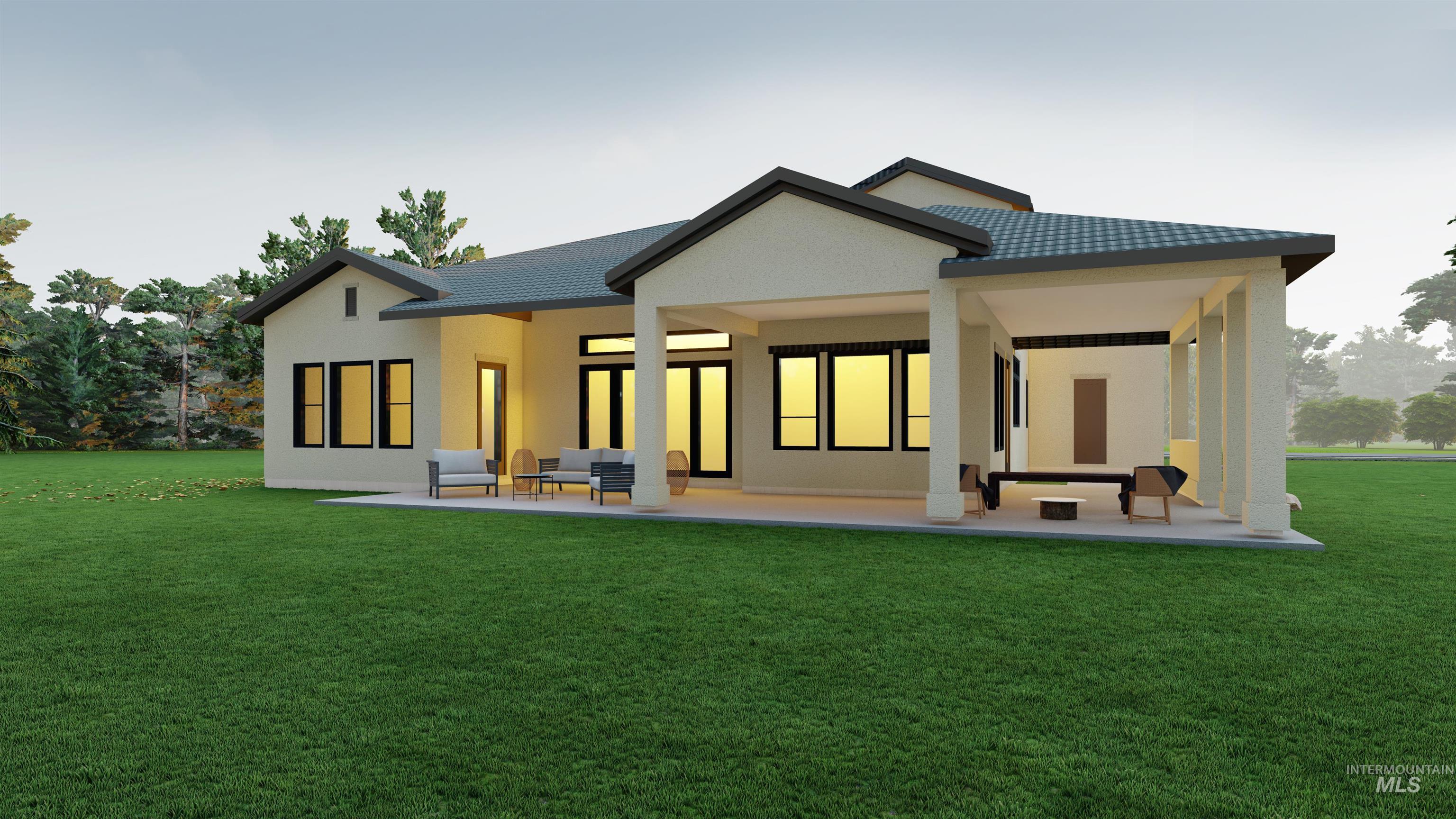 Back of house at dusk featuring a patio, a lawn, a tiled roof, and stucco siding