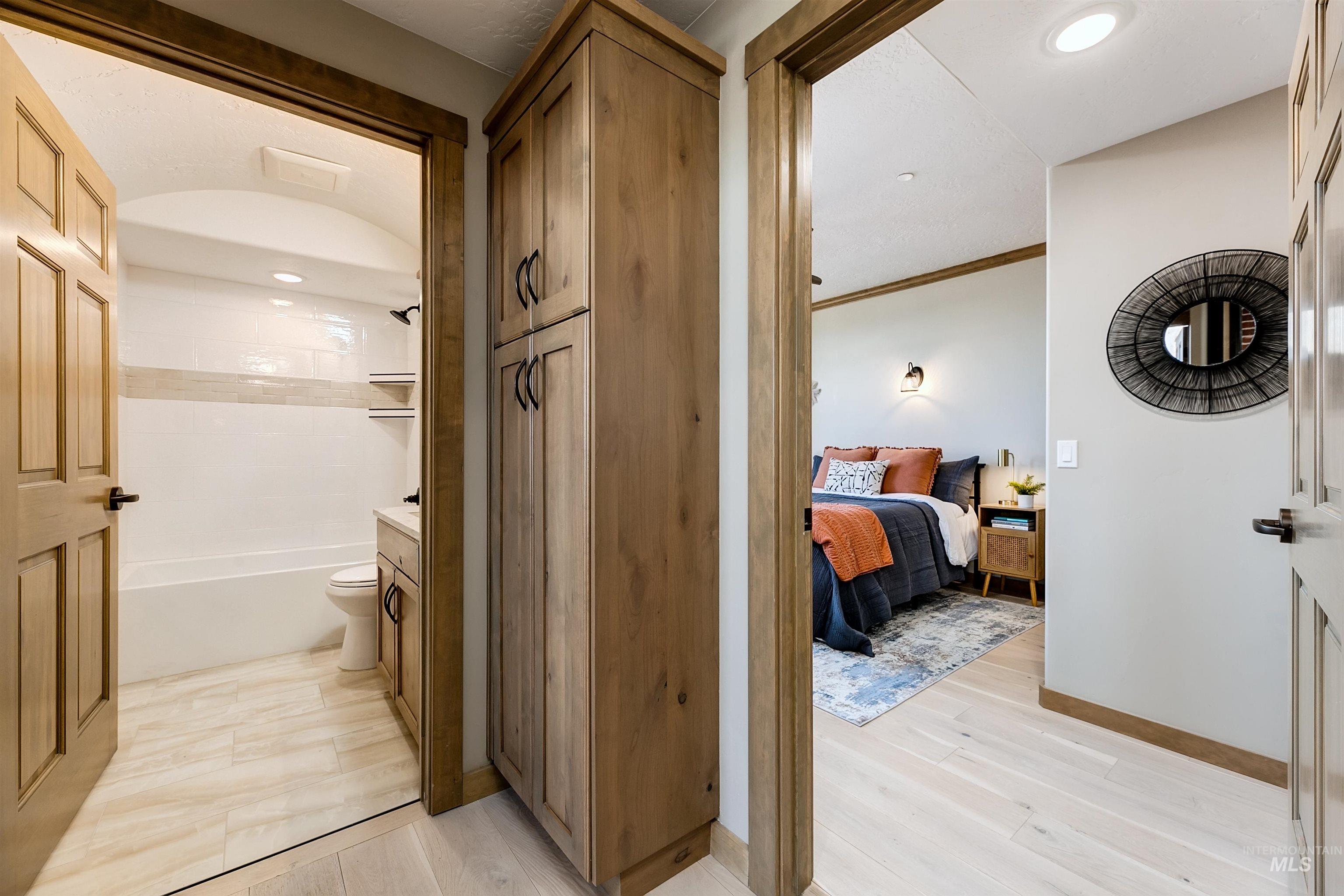 Ensuite bathroom featuring tub / shower combination, recessed lighting, ornamental molding, vanity, and light wood-style flooring