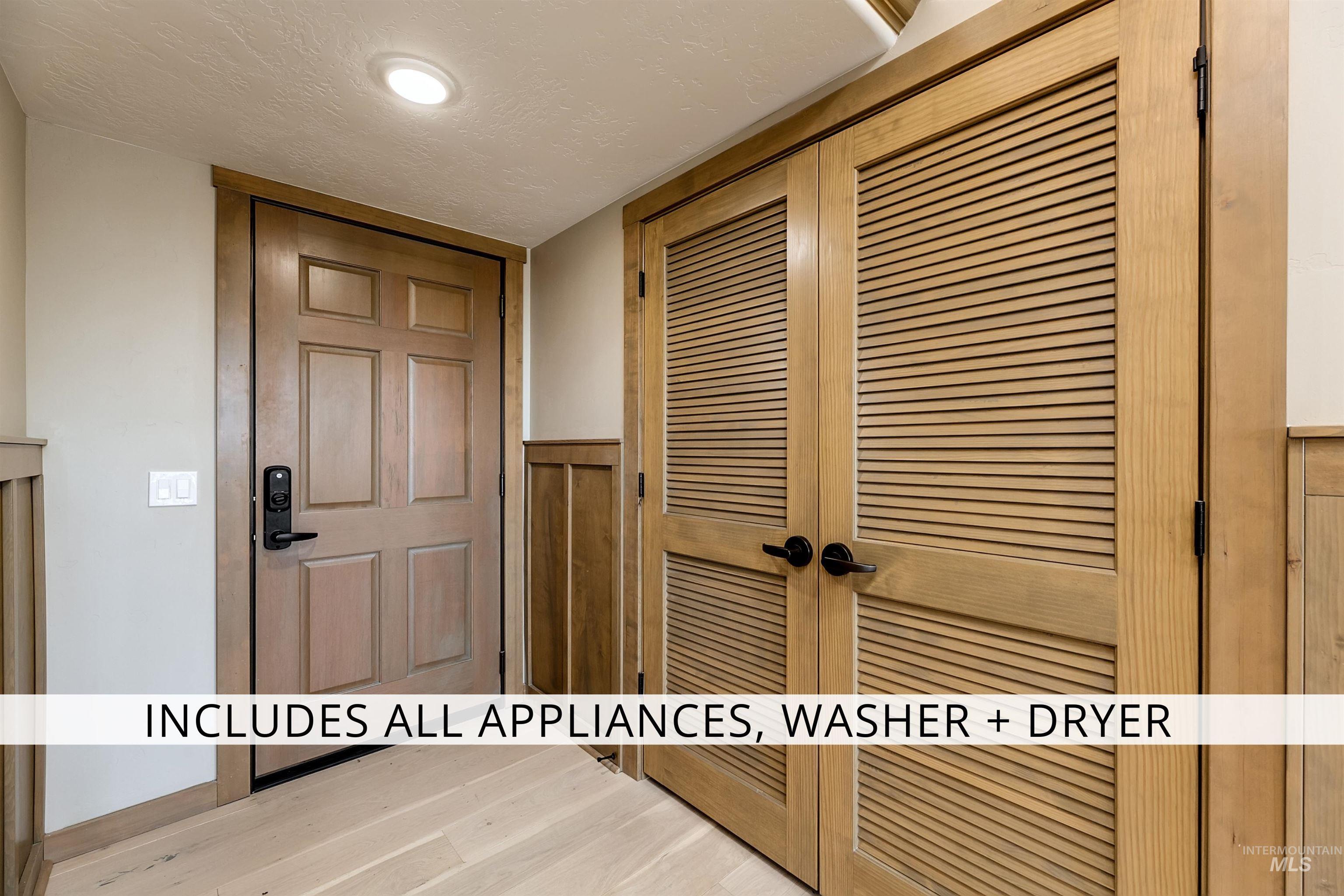 Interior space featuring a textured ceiling, wood finished floors, and wainscoting