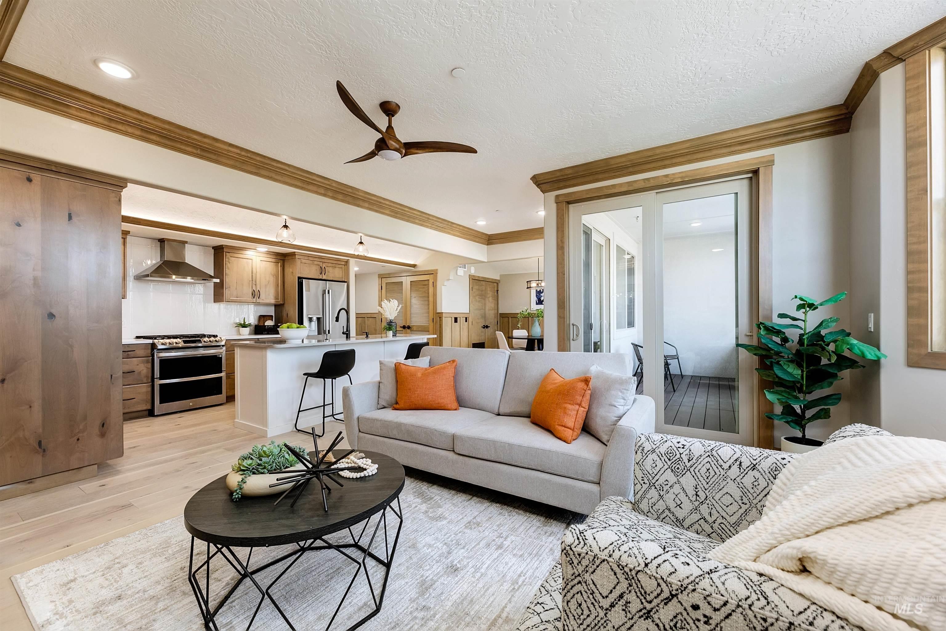 Living area with crown molding, light wood-style flooring, ceiling fan, recessed lighting, and a textured ceiling