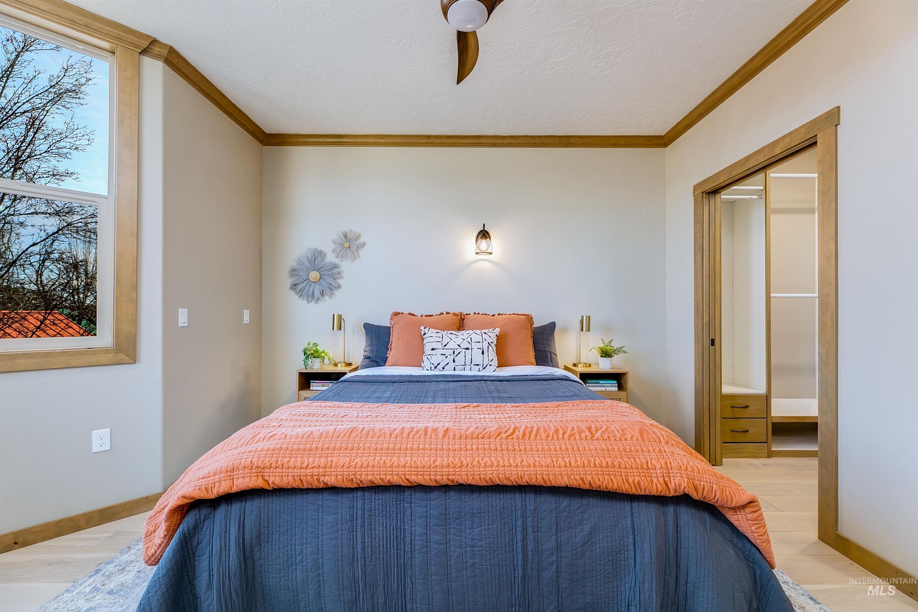 Bedroom featuring ornamental molding, a closet, light wood finished floors, and ceiling fan