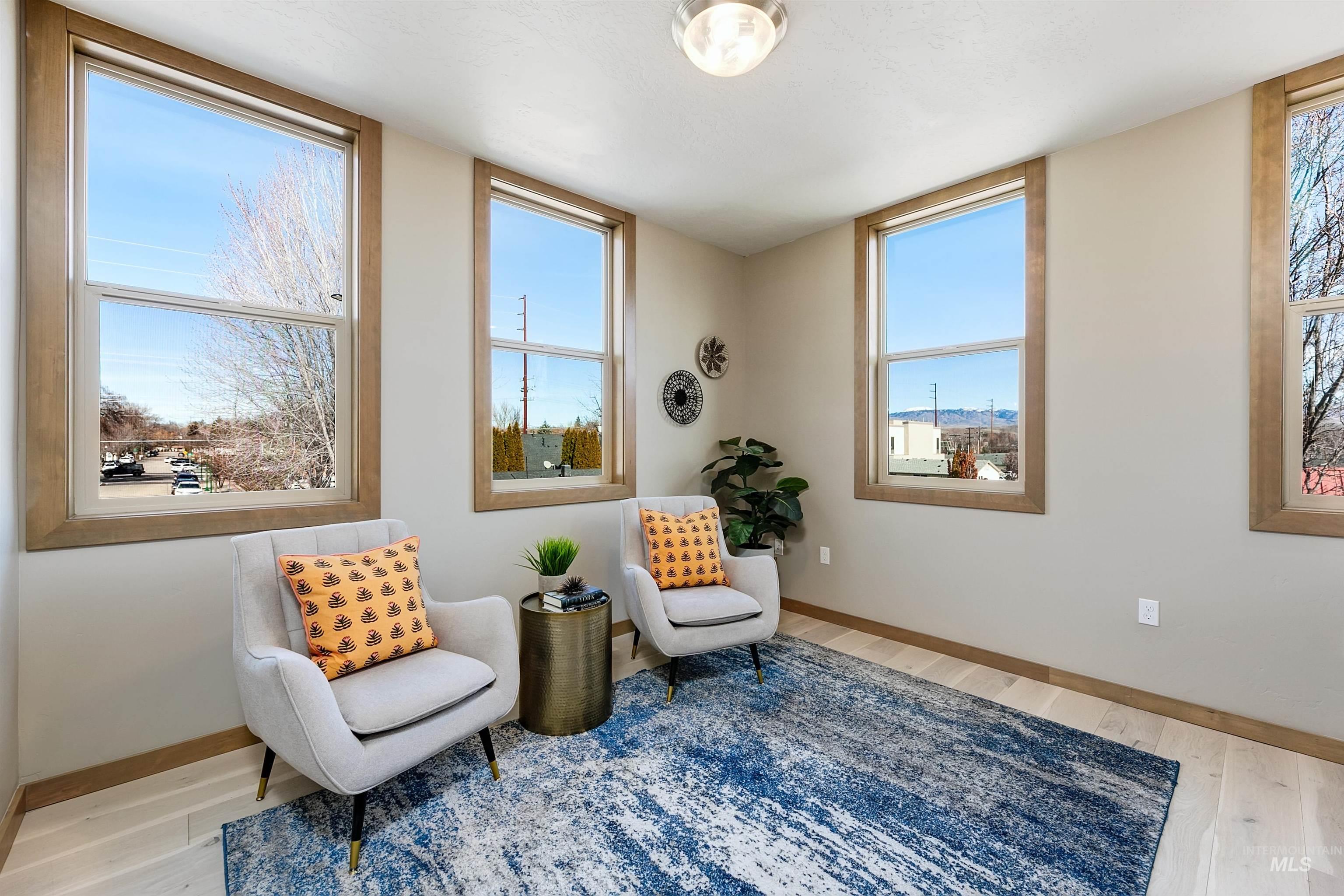 Sitting room with light wood-style floors and healthy amount of natural light