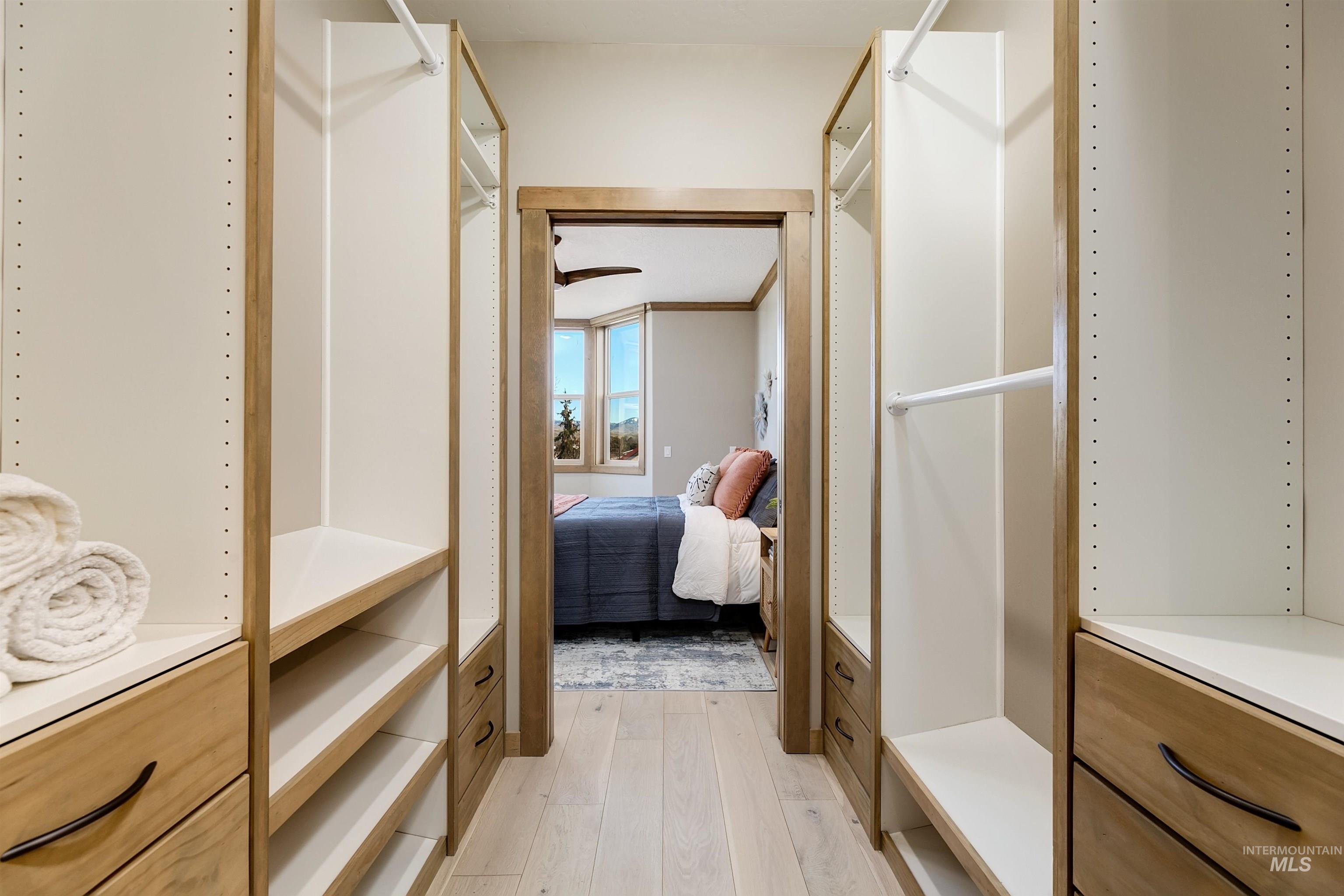 Walk in closet with light wood-type flooring