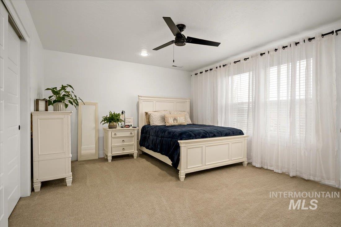 Bedroom featuring light colored carpet and ceiling fan