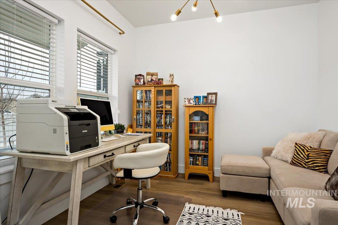 Office area featuring dark wood finished floors and a chandelier