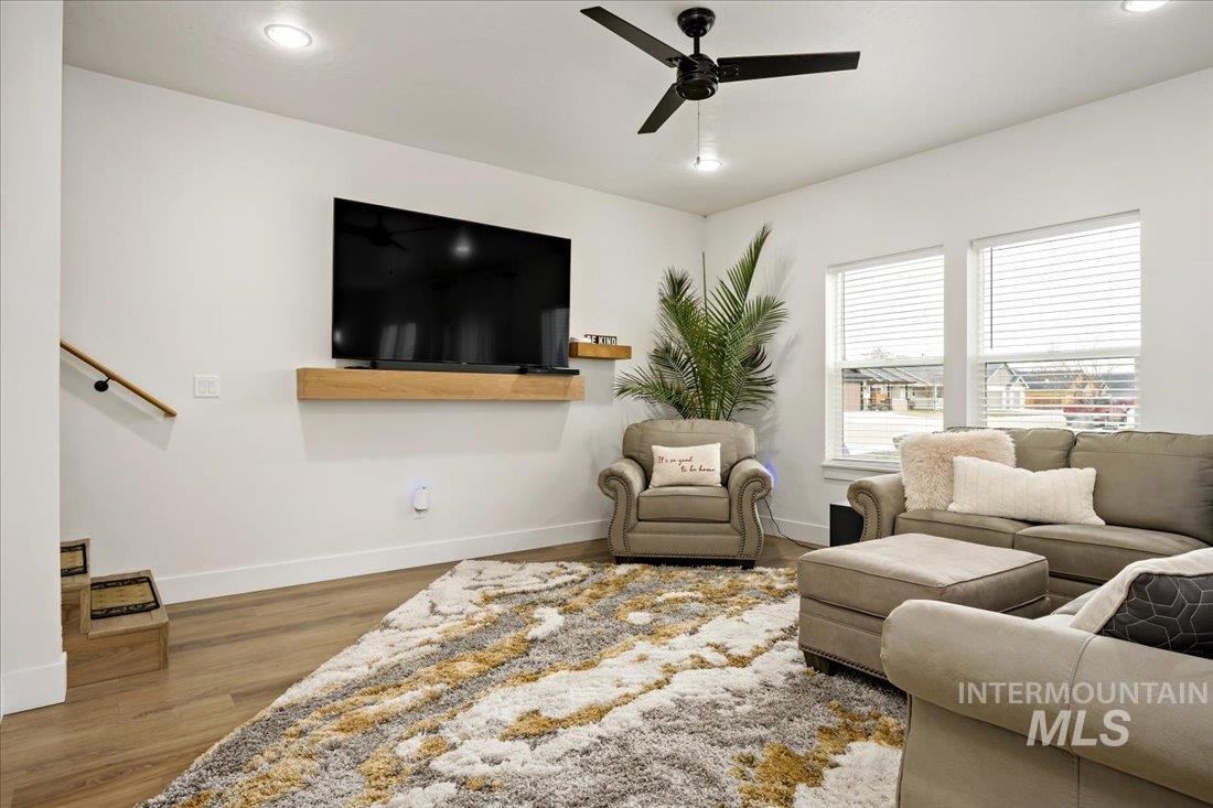 Living area with recessed lighting, wood finished floors, and ceiling fan
