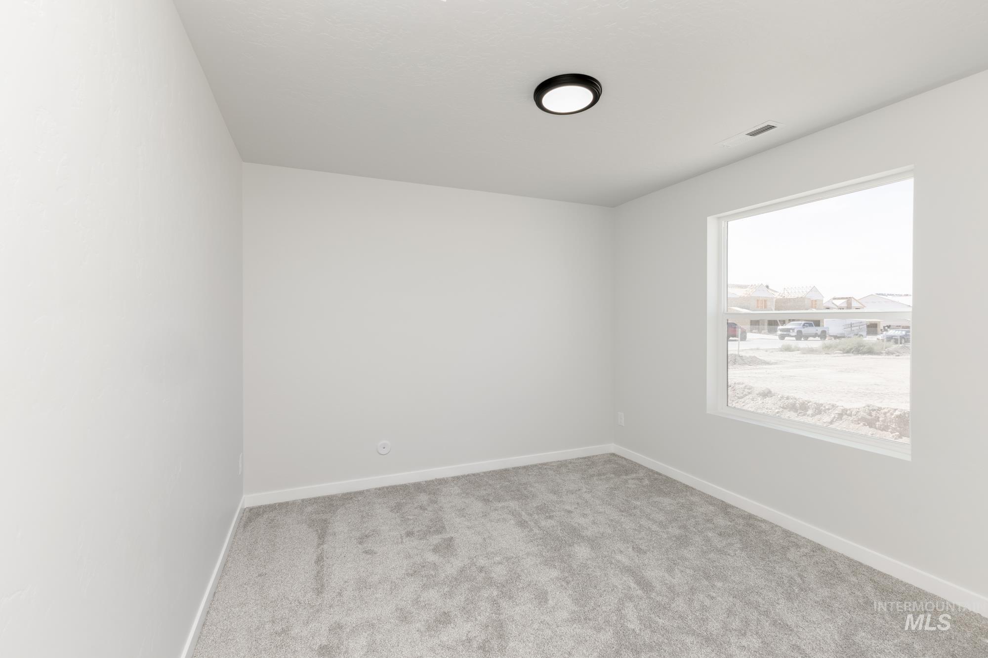 Unfurnished room featuring light colored carpet and baseboards