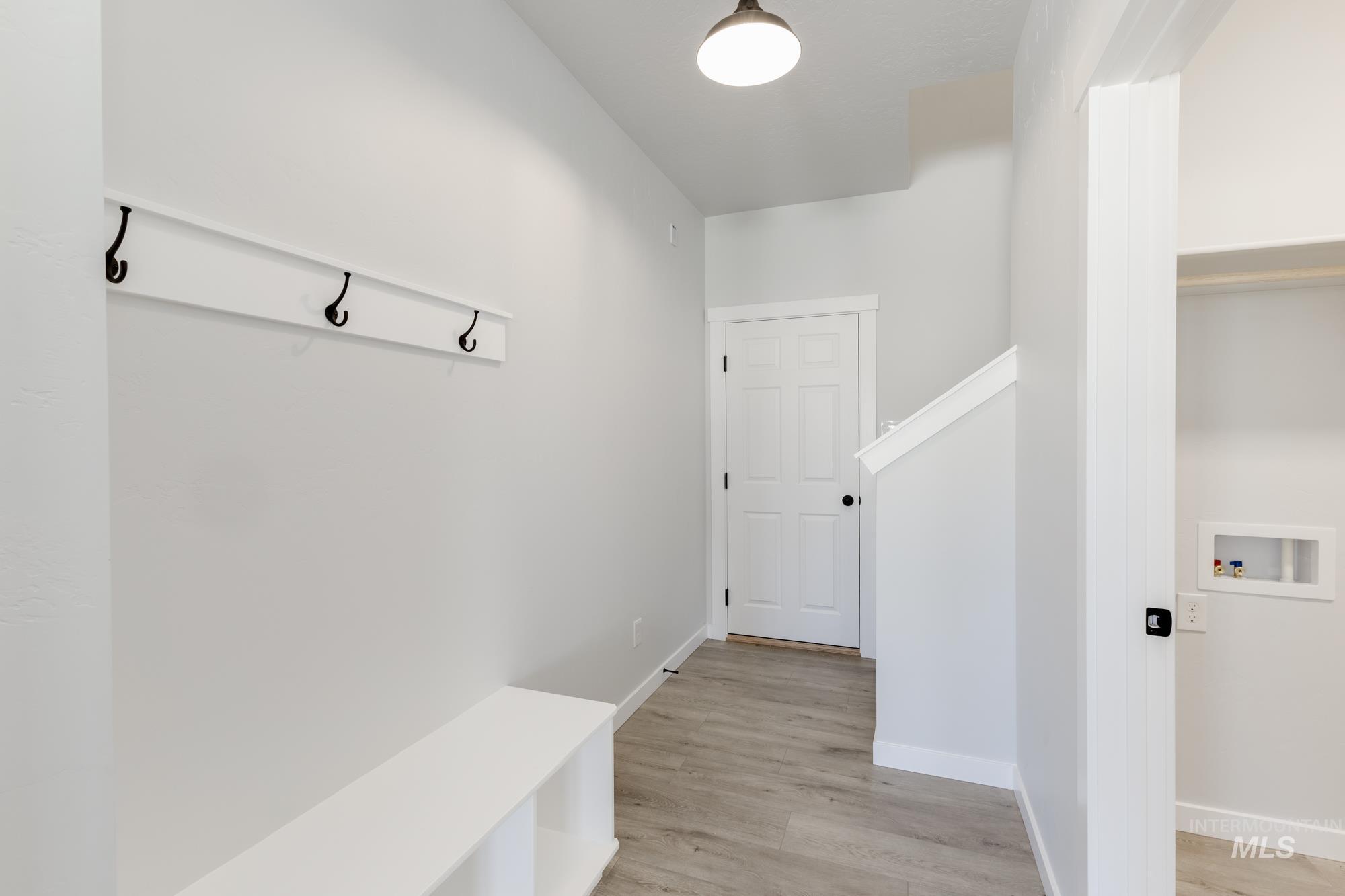Mudroom featuring light wood-style floors and baseboards