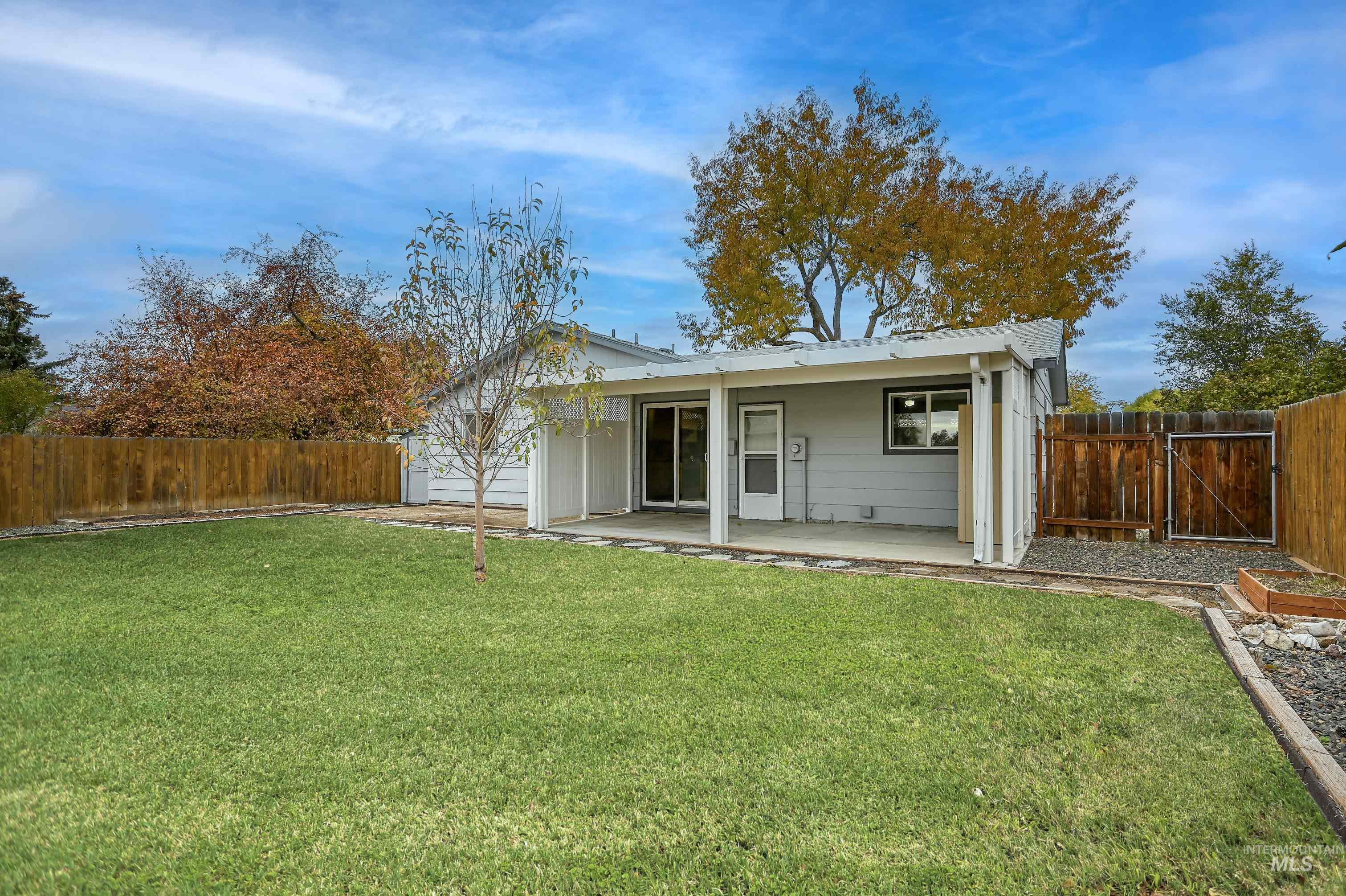 Rear view of property featuring a fenced backyard, a patio area, and a gate