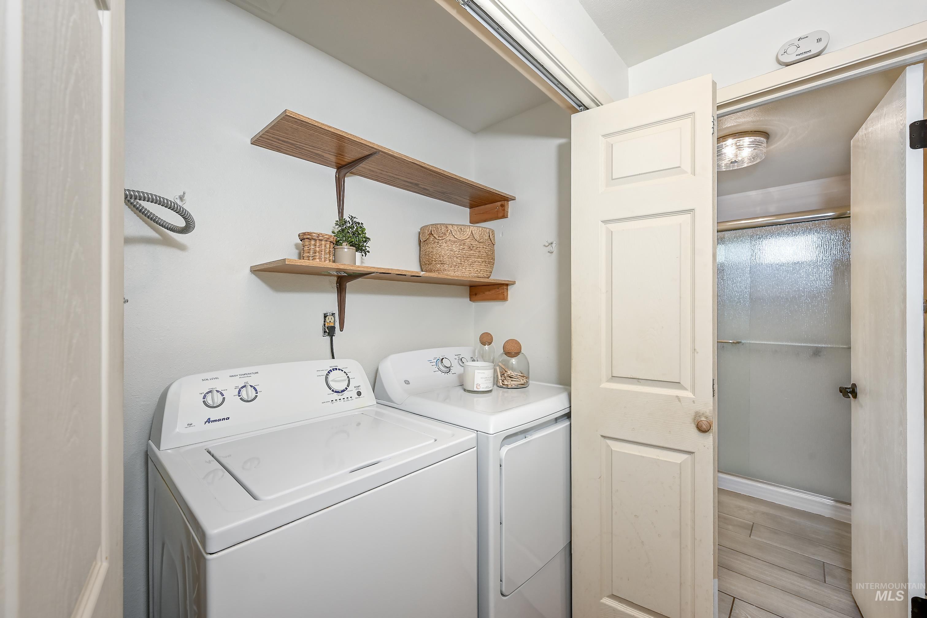 Laundry room featuring light wood-style floors and washing machine and dryer